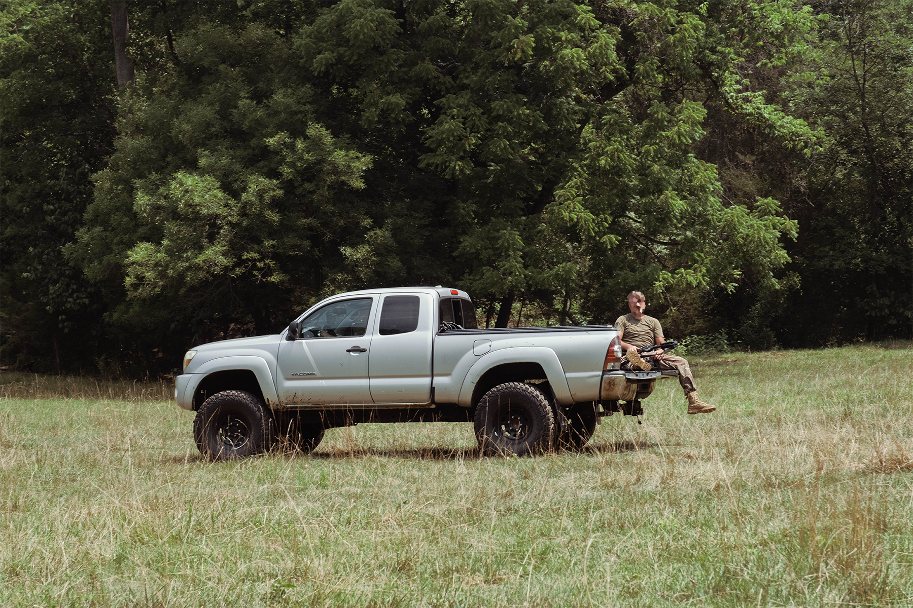 A militiaman riding in the back of a truck to a different section of the training ground. July 18, 2026.