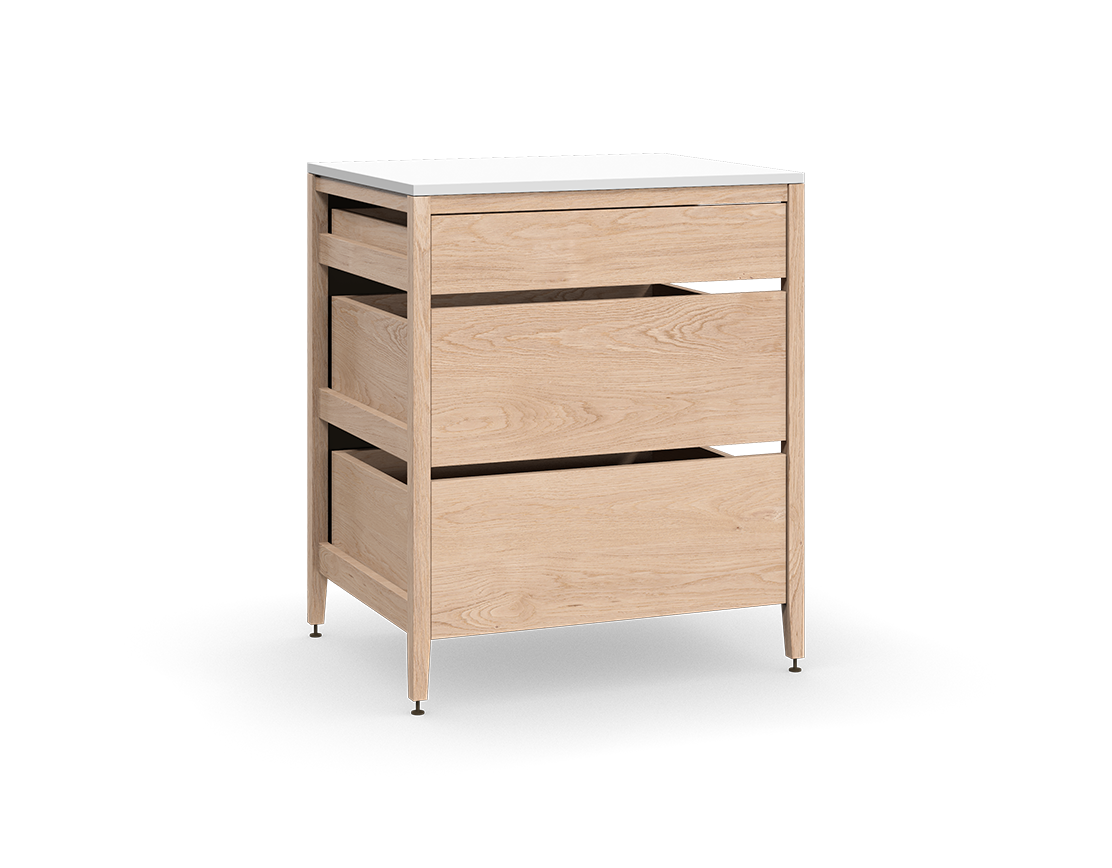 Cabinet de cuisine autoportant en chêne naturel, avec trois tiroirs en bois et des pieds en métal bronze.
