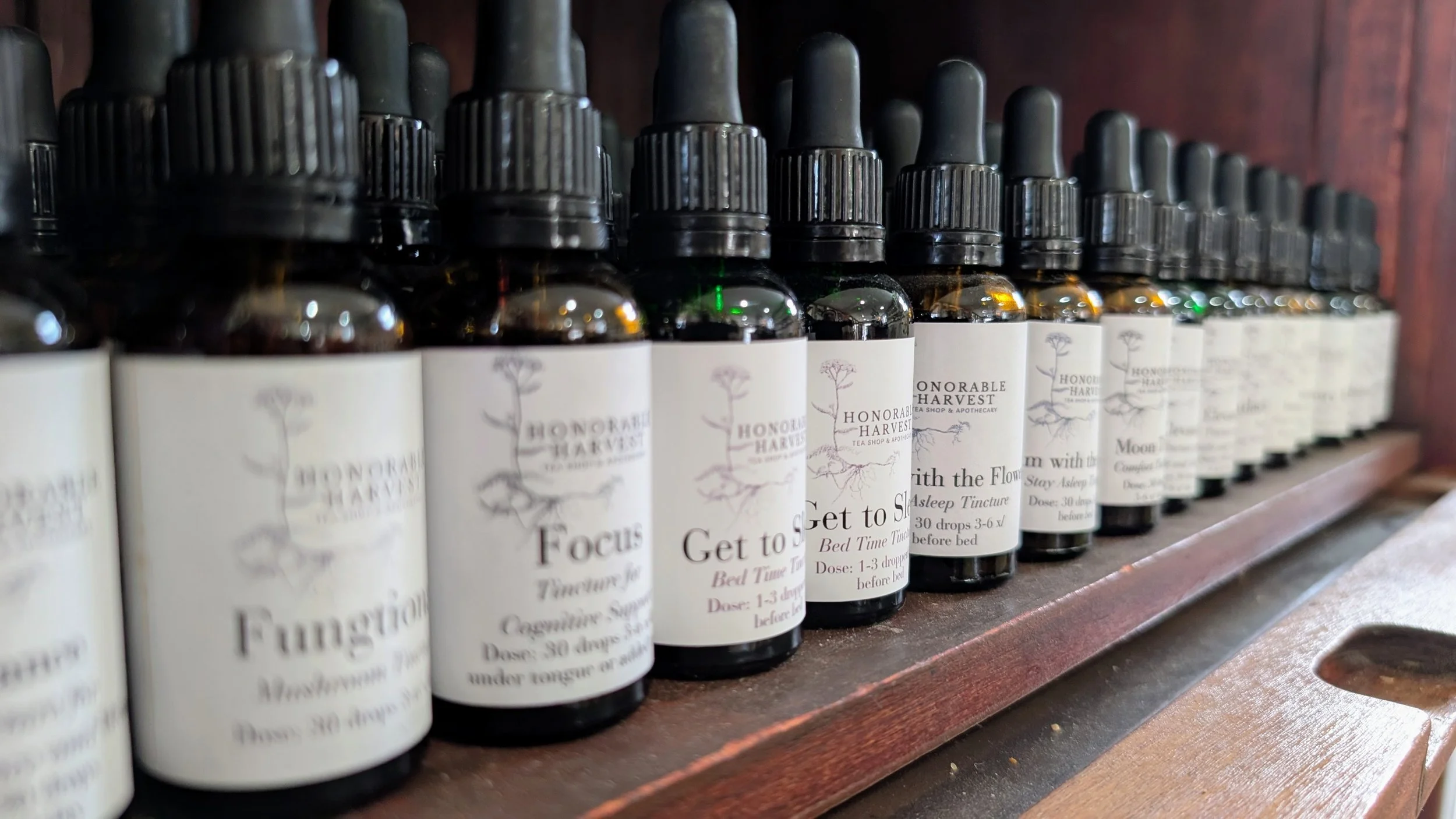 A lineup of small-batch, house-formulated herbal tinctures on the shelves at Honorable Harvest.