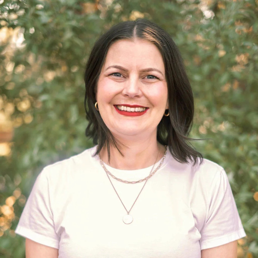 Head and shoulders of Elisa Earwicker with foliage behind her