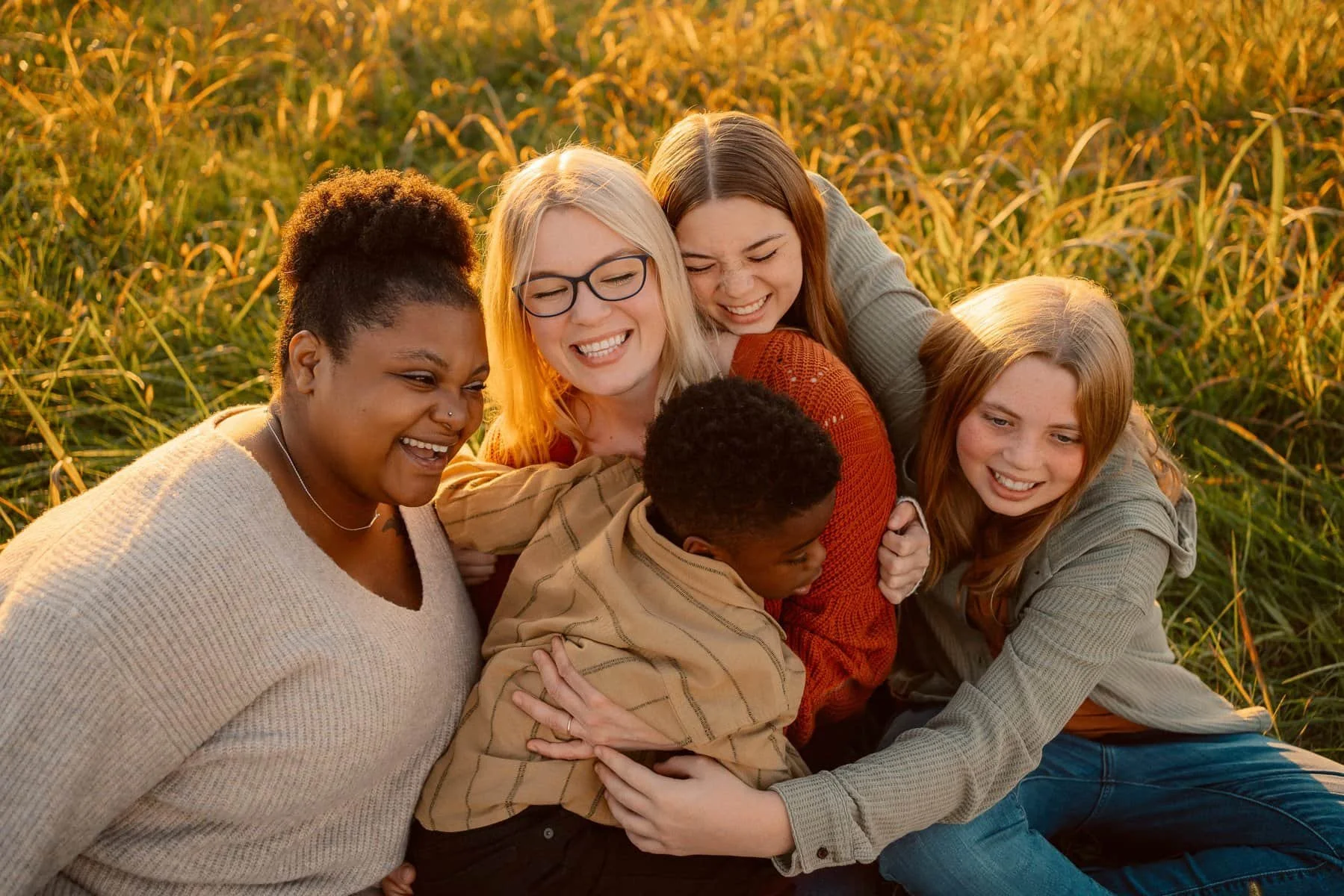 image of Andria Fontenot, Lynchburg Newborn Photographer and her children sitting in a field