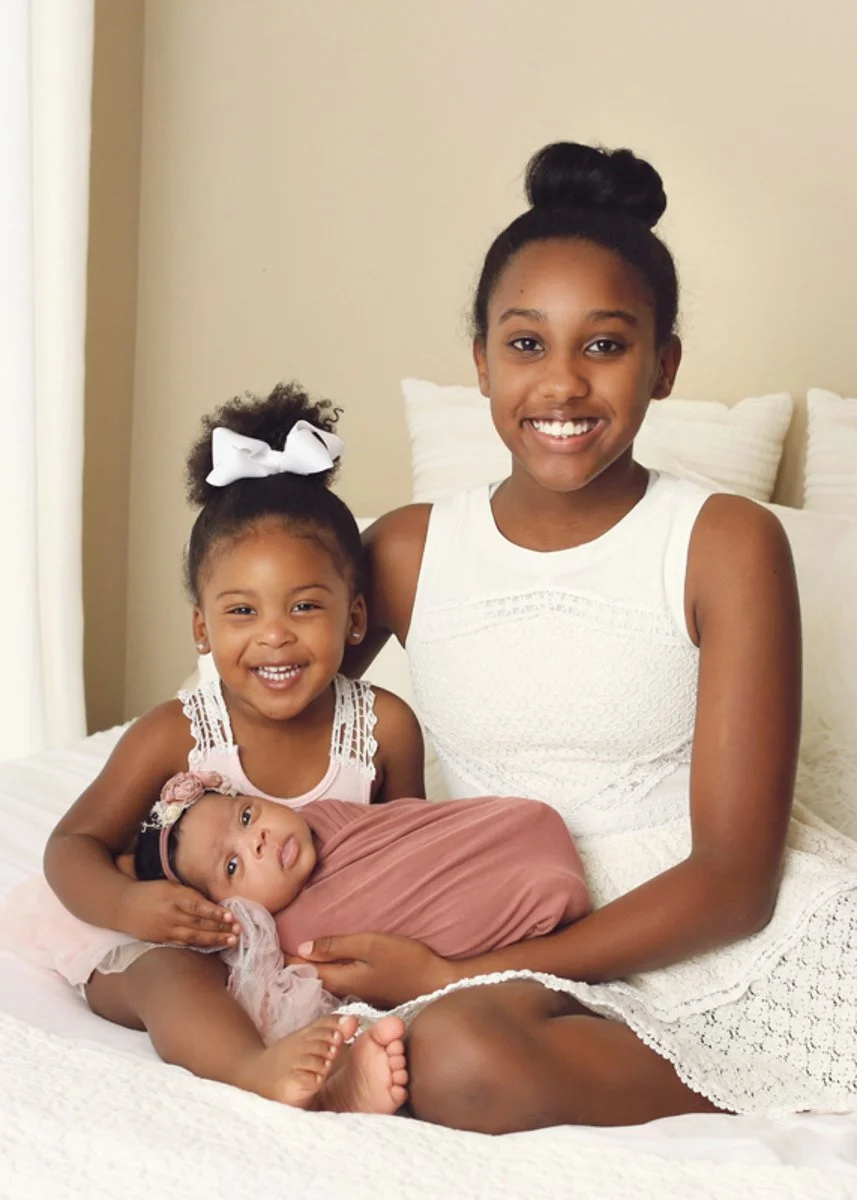 sibling poses on bed newborn session.jpg