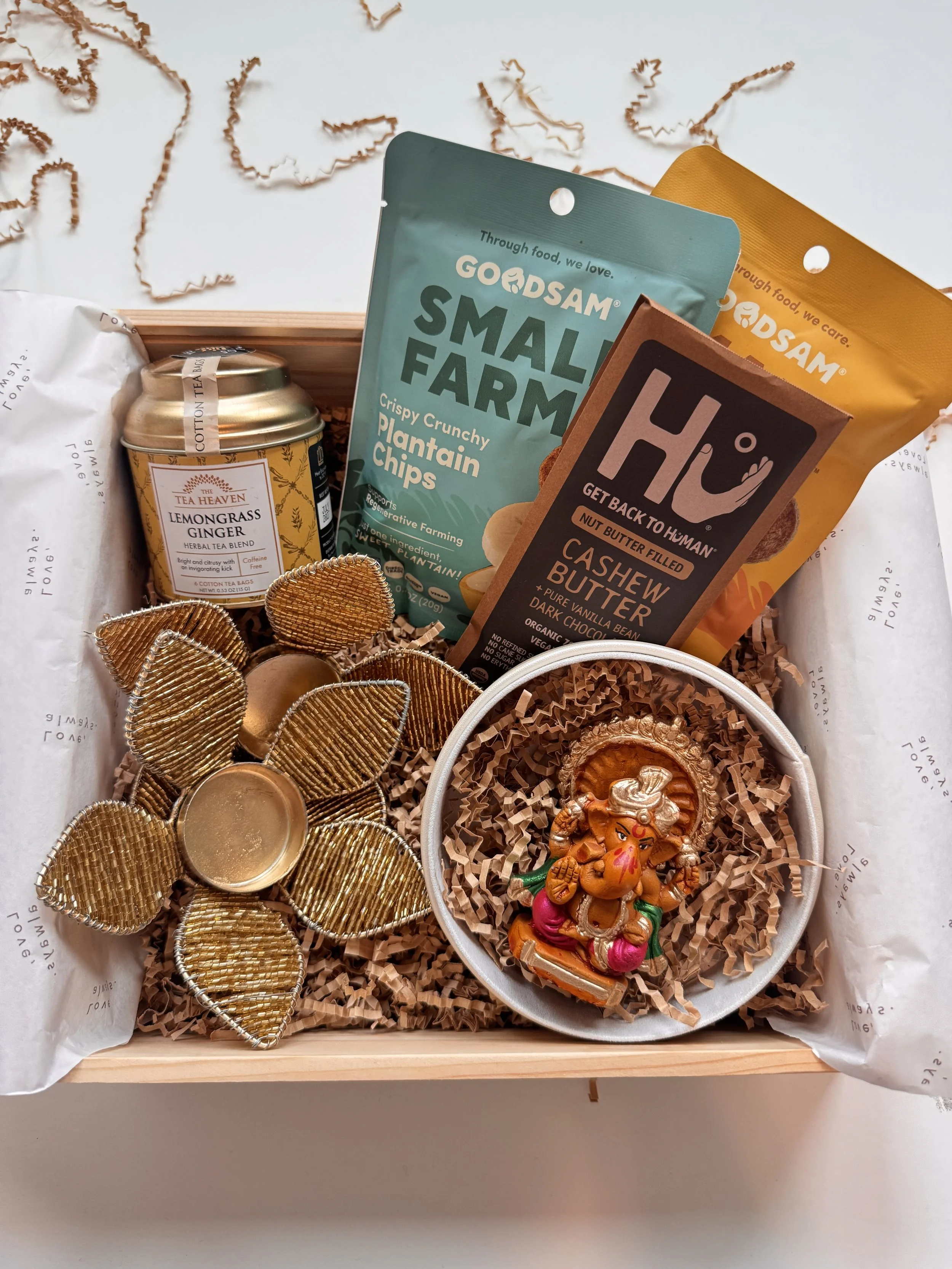 Diwali gift box with Ganesh idol, gourmet snacks, tea, and chocolate arranged in a wooden box by Go Gaga Gifts