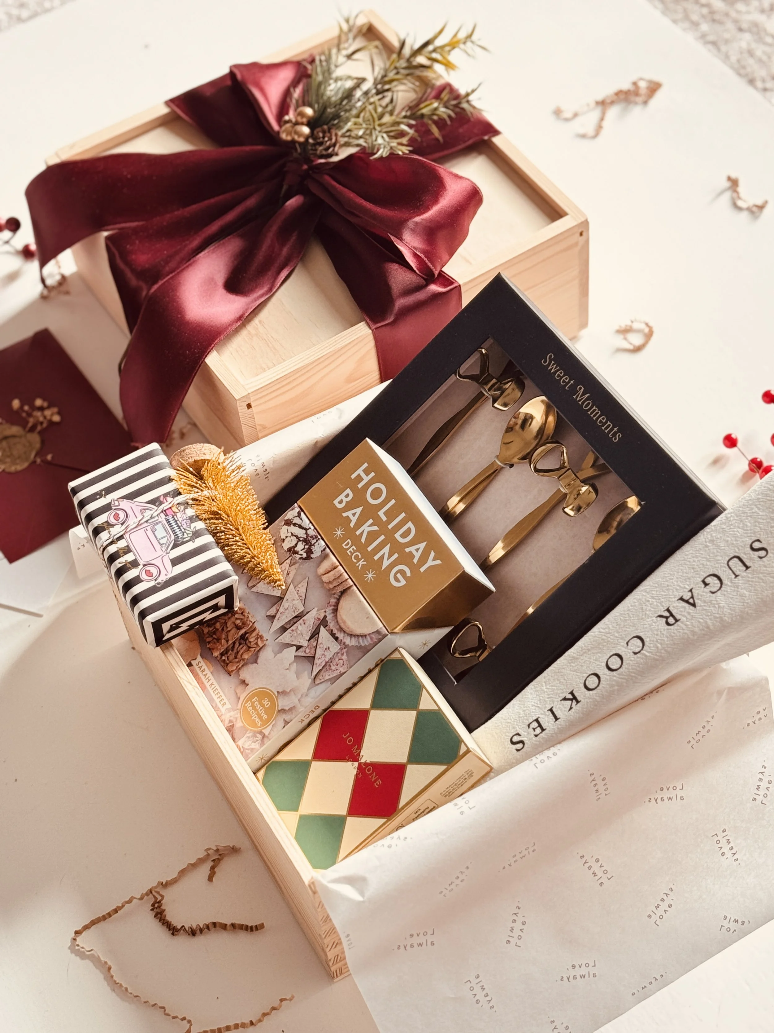 Sweet Holiday Gift Box with gold teaspoon set, Jo Malone mini fragrance duo, holiday baking recipe cards, festive soap, and burgundy ribbon packaging