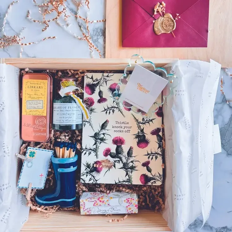Gift box with flower-themed items and a card.