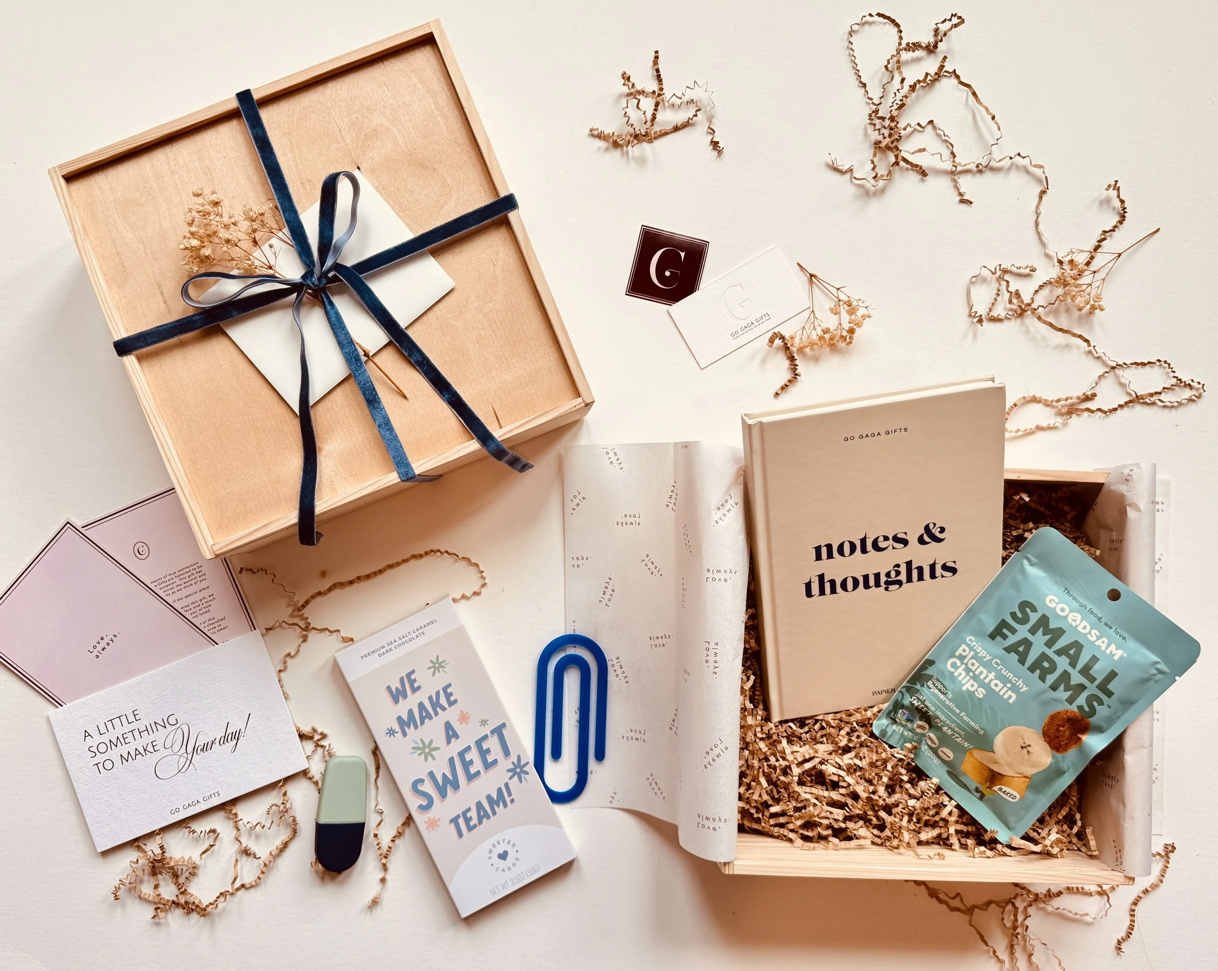 Curated thank-you gift box with “Notes & Thoughts” notebook, artisanal chocolate, healthy snack pack, and navy ribbon detail in a pinewood box.