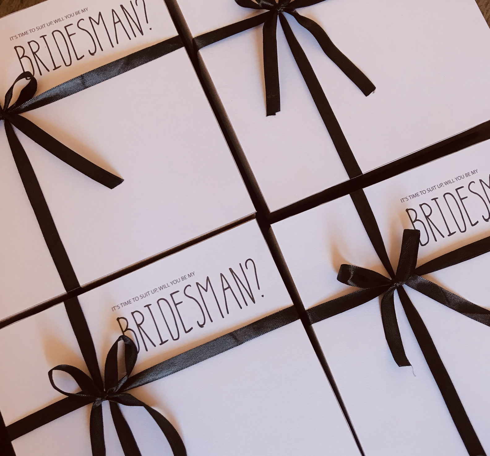 Bridesman proposal gift boxes with sleek black ribbons and bold typography reading “It’s time to suit up, will you be my Bridesman?