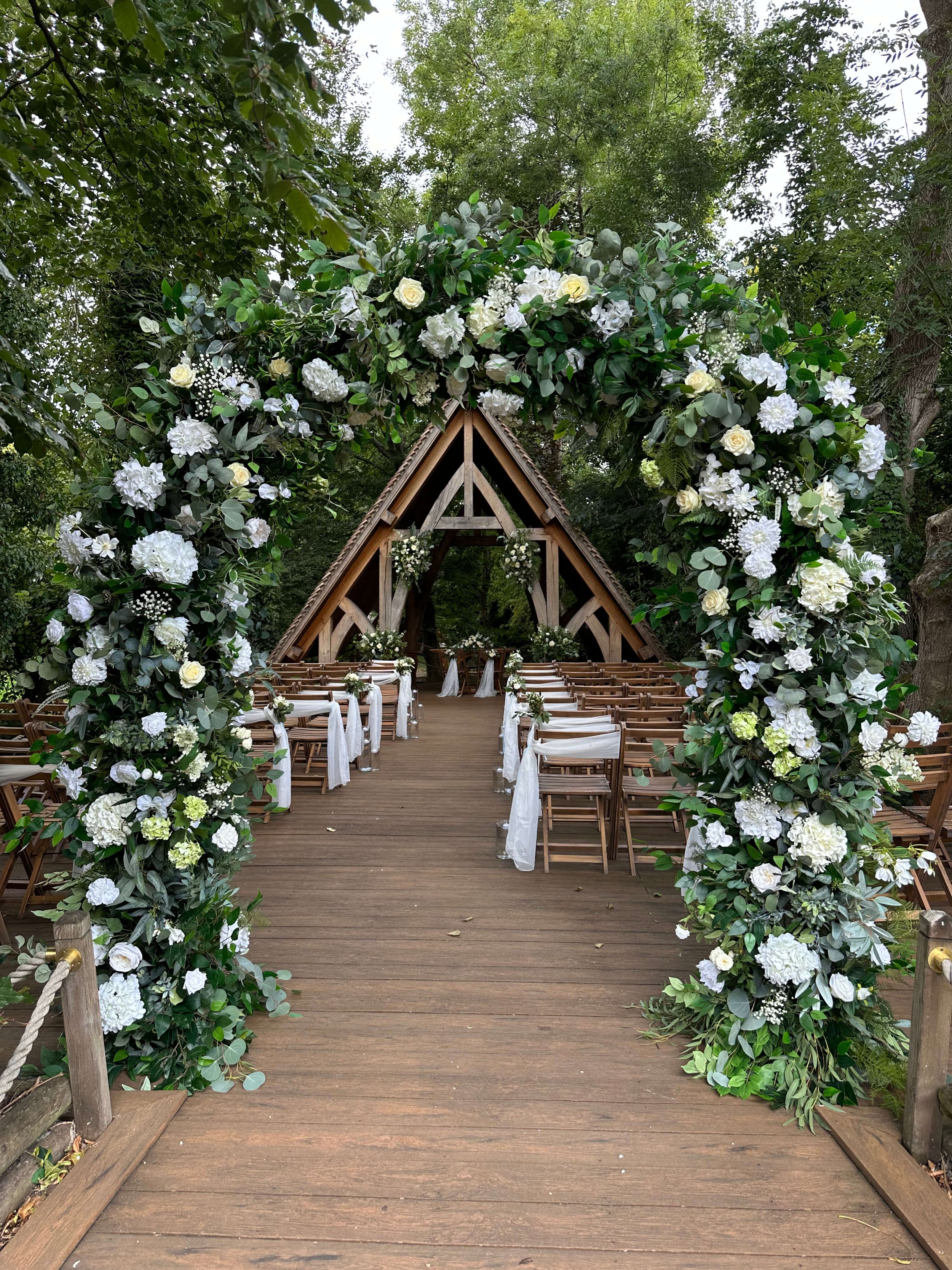 Elegant white faux floral wedding arch with professional styling and setup included. Available for hire across Surrey and nearby areas