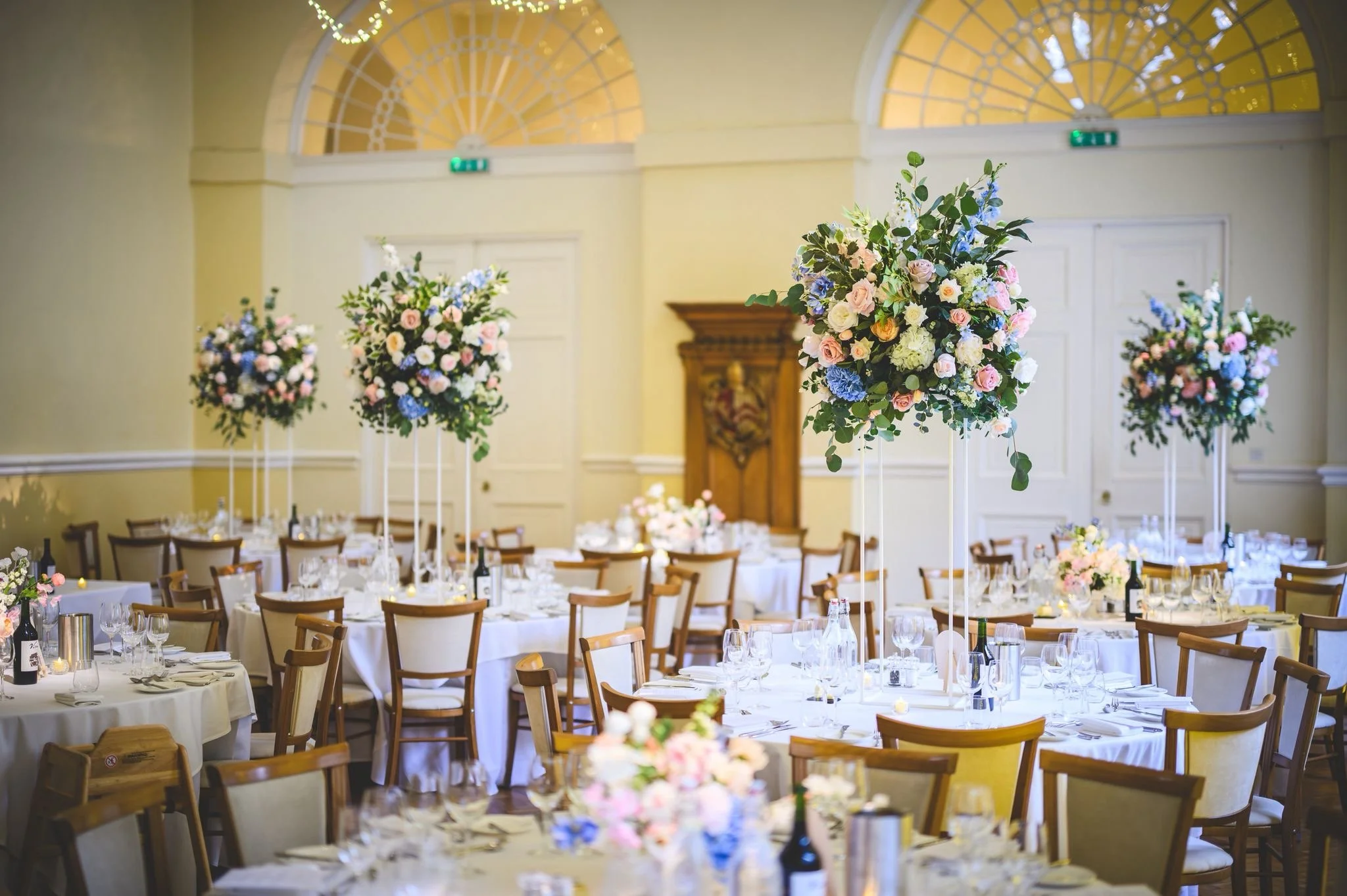 Blush and ivory tall wedding centrepiece at Farnham Castle with roses, hydrangea and soft greenery