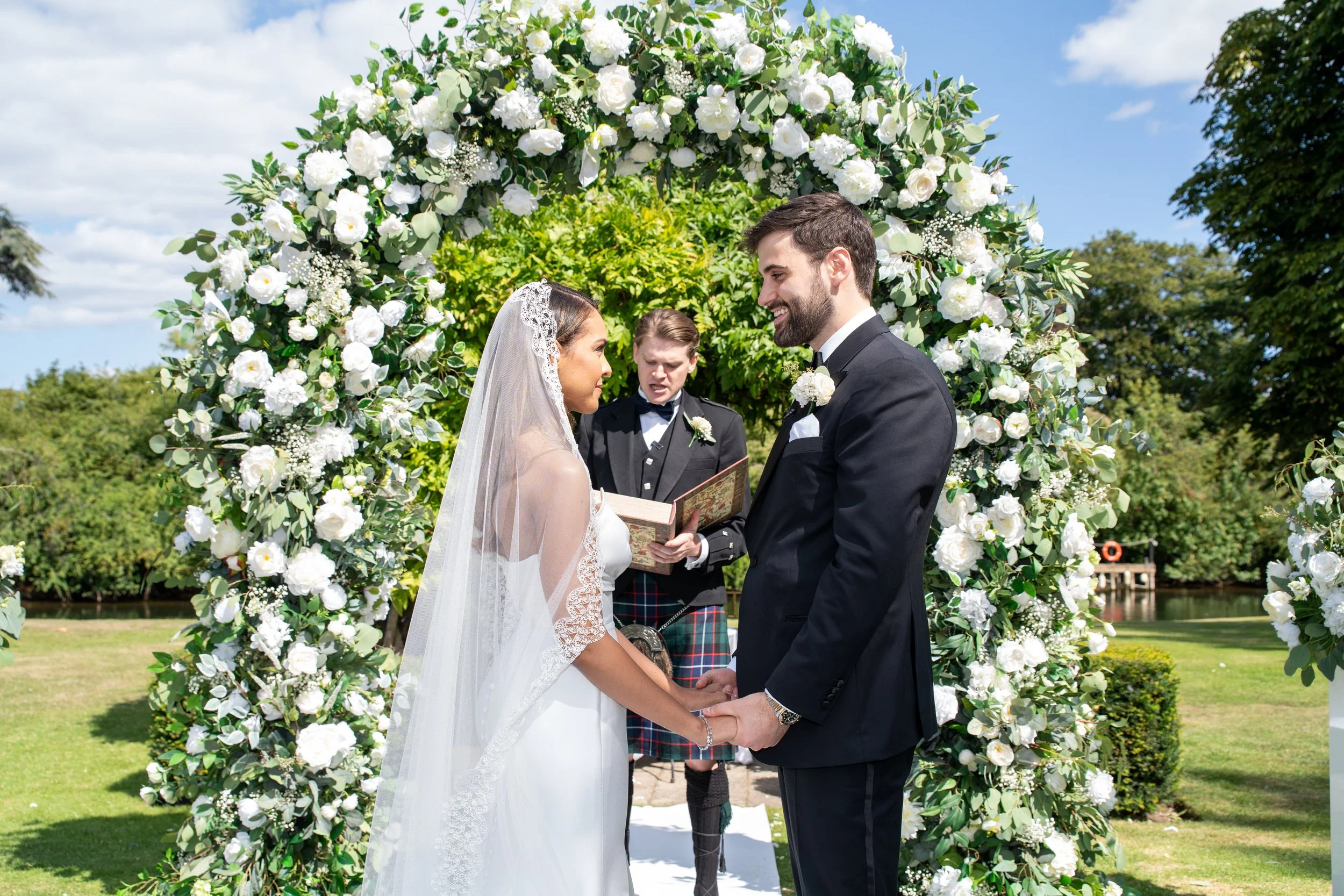 Elegant white faux artificial floral wedding arch with professional styling and setup included. Available for hire across Surrey and nearby areas.