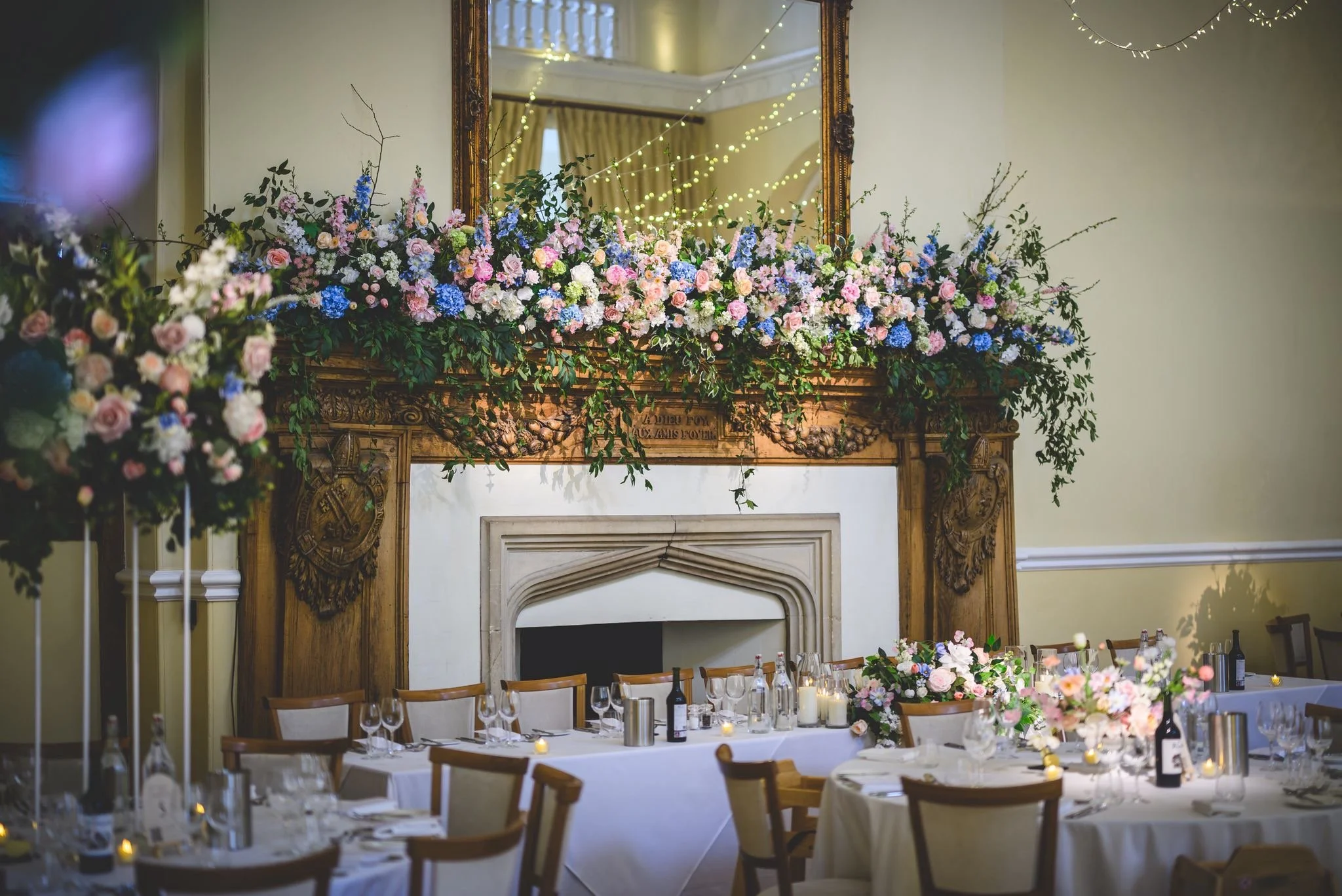 Grand fireplace wedding flower arrangement  at Farnham Castle in blush, ivory and blue colours