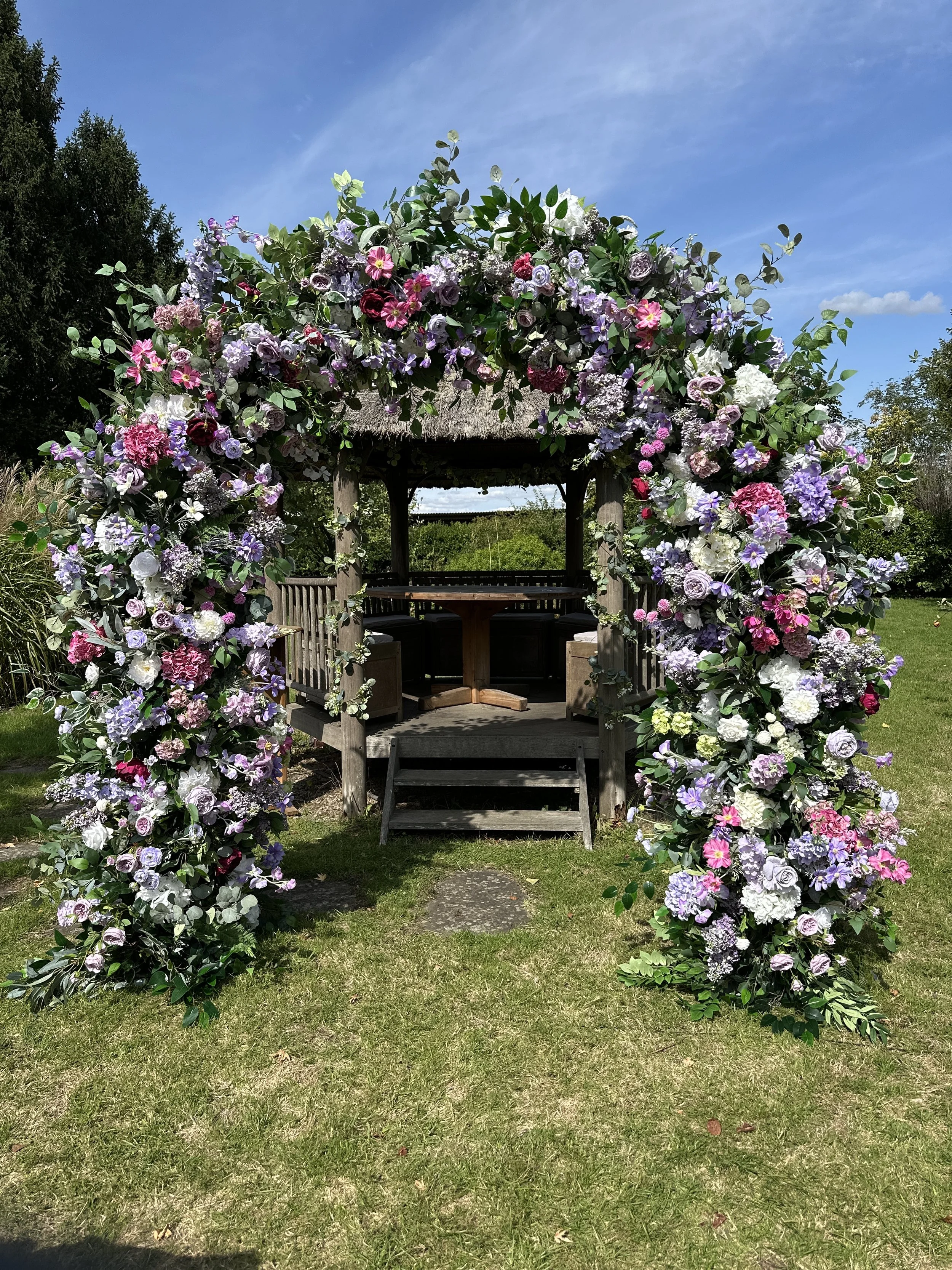 Hire Luxury faux floral wedding arch in lilac, ivory, mauve purple and deep pink tones. Premium artificial flowers with professional setup included. Available across Surrey.
