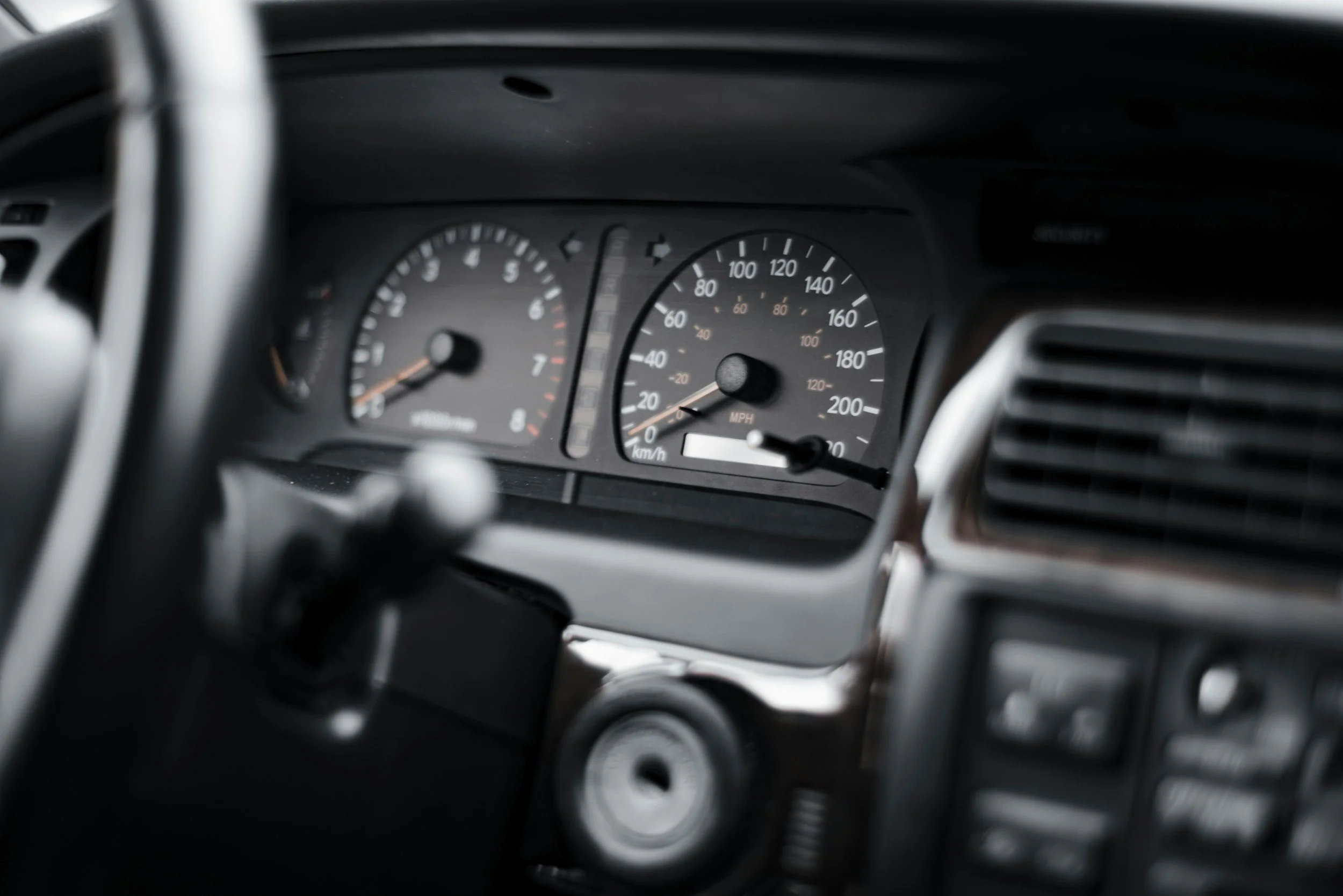 Close-up of a car dashboard with speedometer and tachometer.