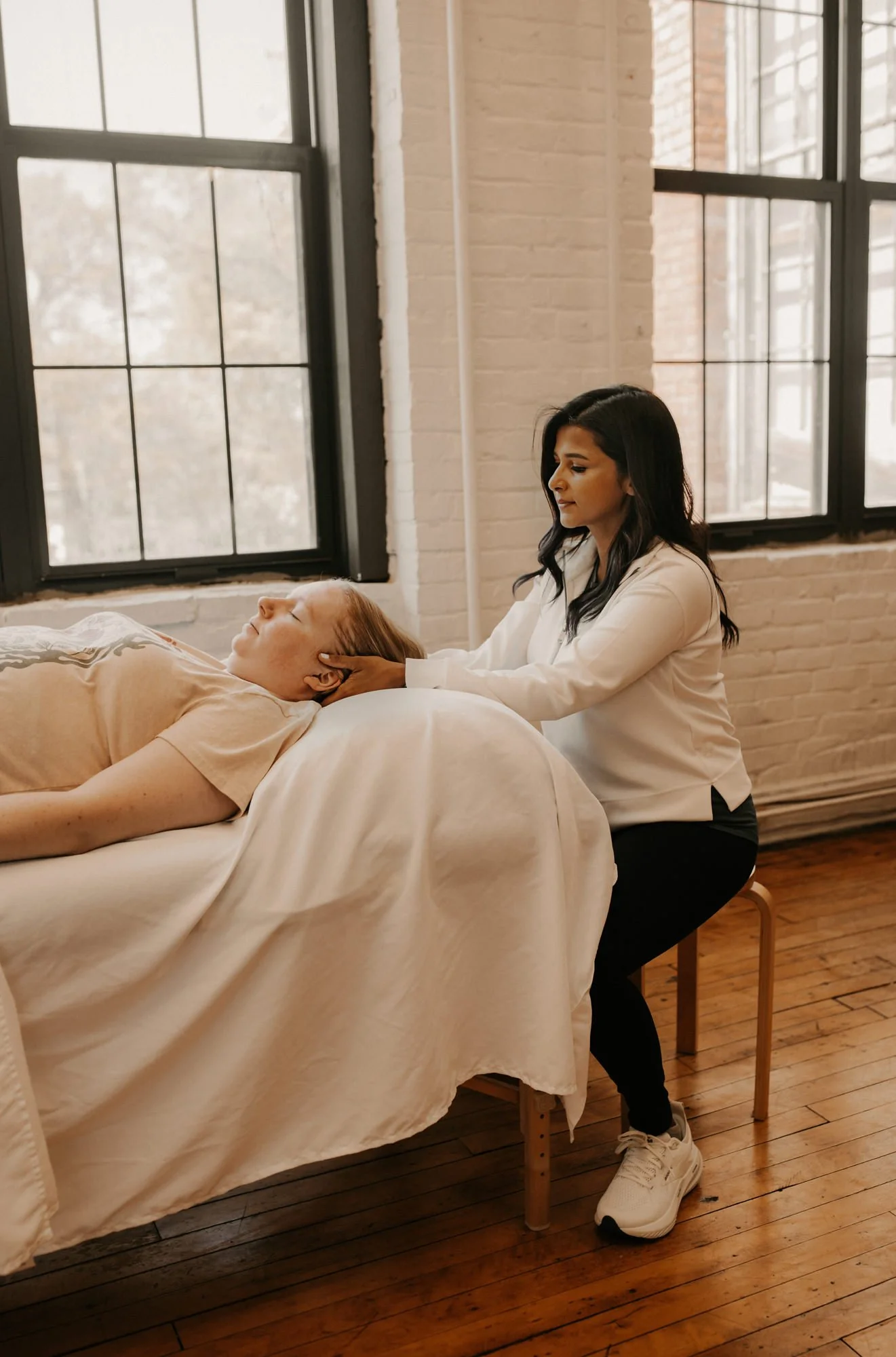 a pelvic floor physical therapist working on a patients neck using manual techniques