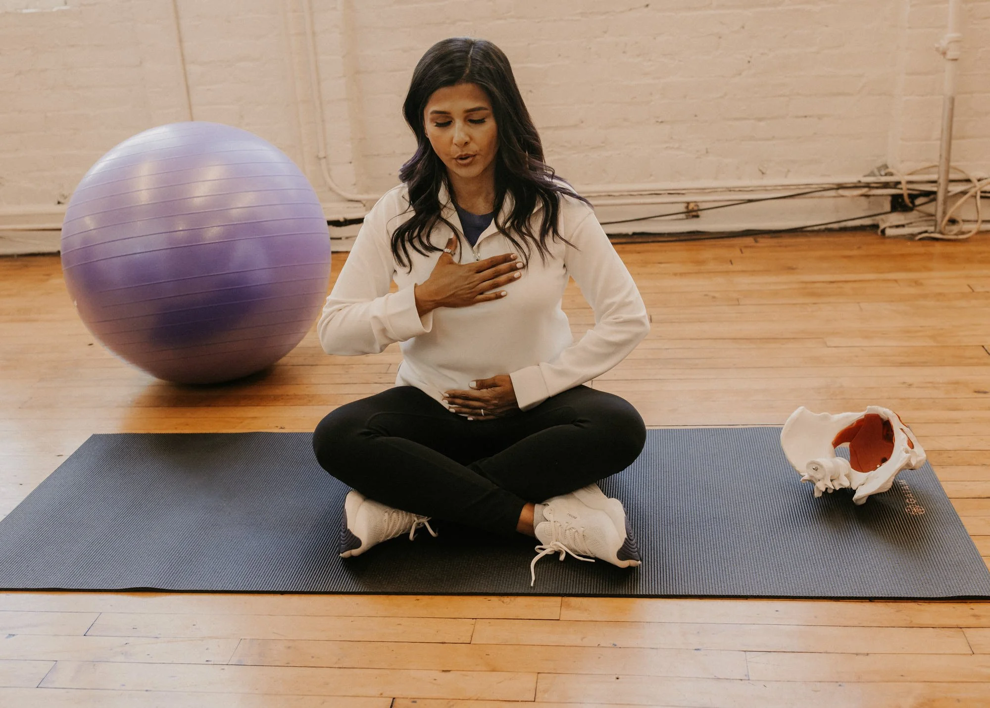 pelvic floor therapist working on breathing in a session.
