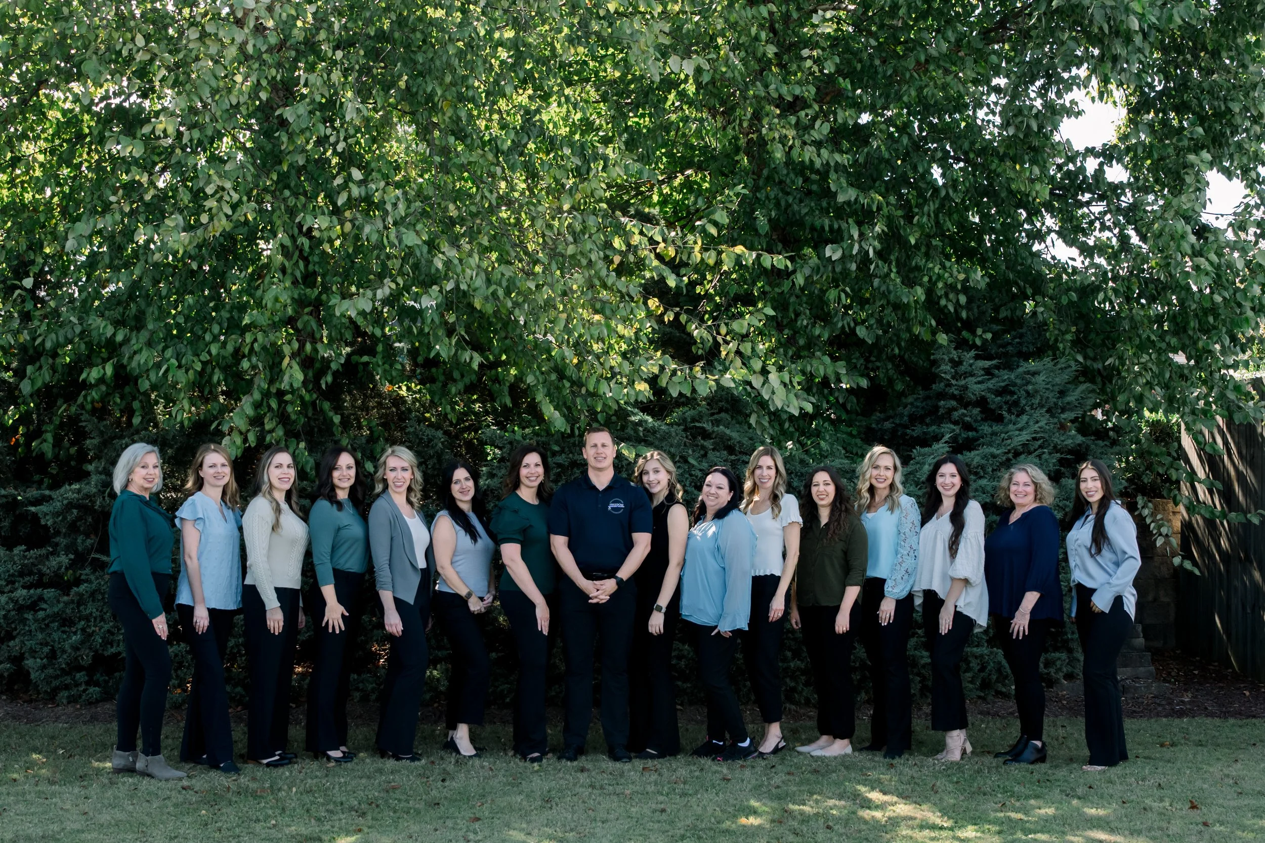 Freedom Integrative Wellness Office team standing under trees