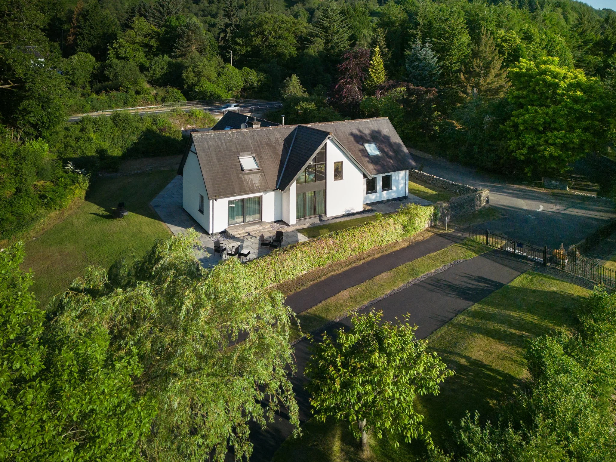 Aerial view of modern countryside house surrounded by greenery and landscape