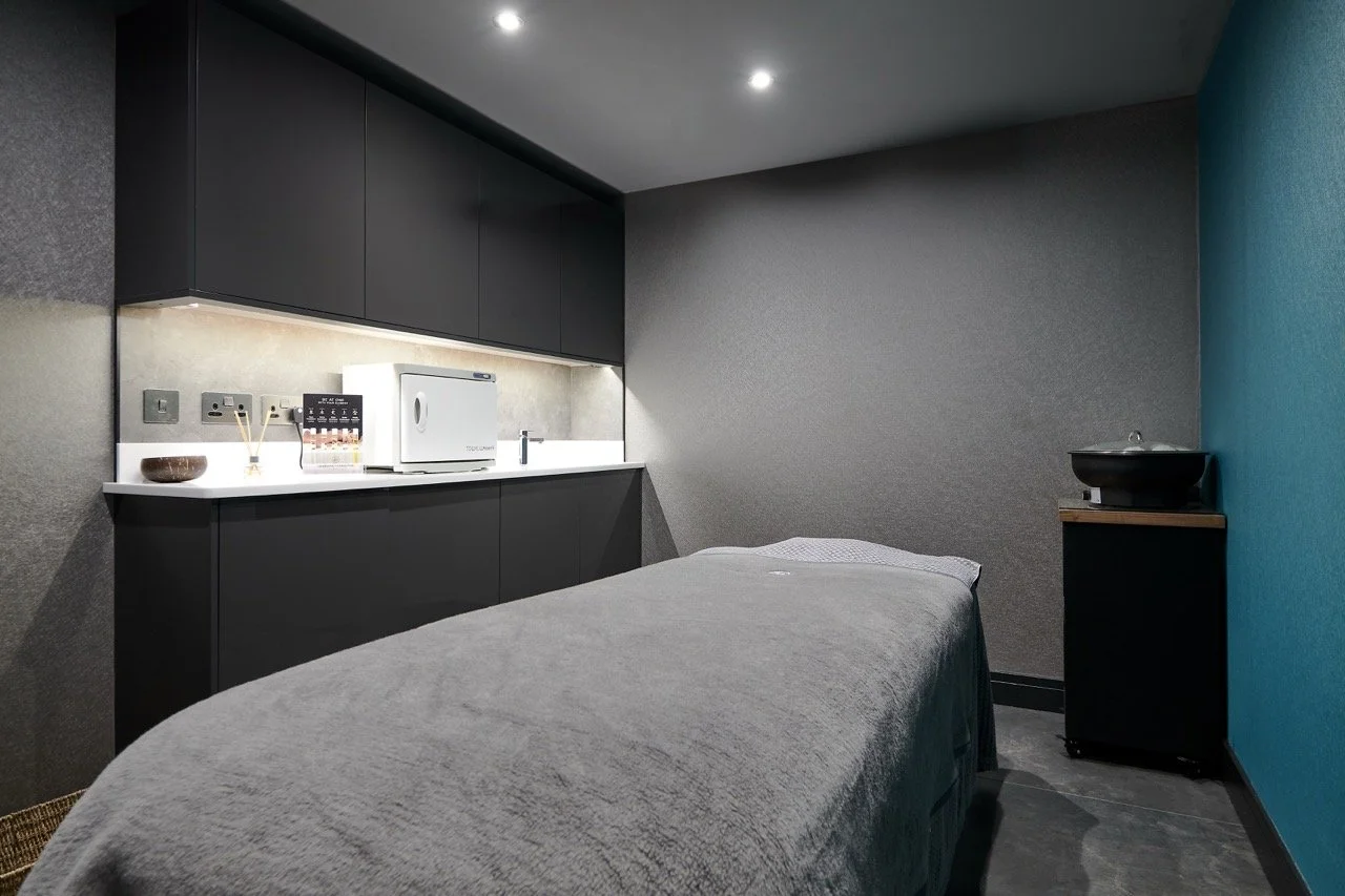 Massage treatment room with soft lighting, modern cabinetry and calm wellness interior design
