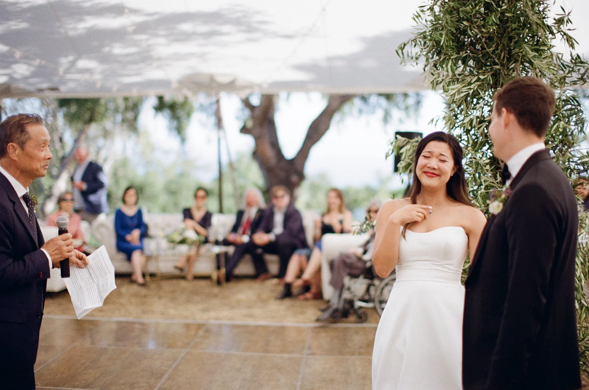 bride and groom listening to a speech photographed by Michael & Anna Costa