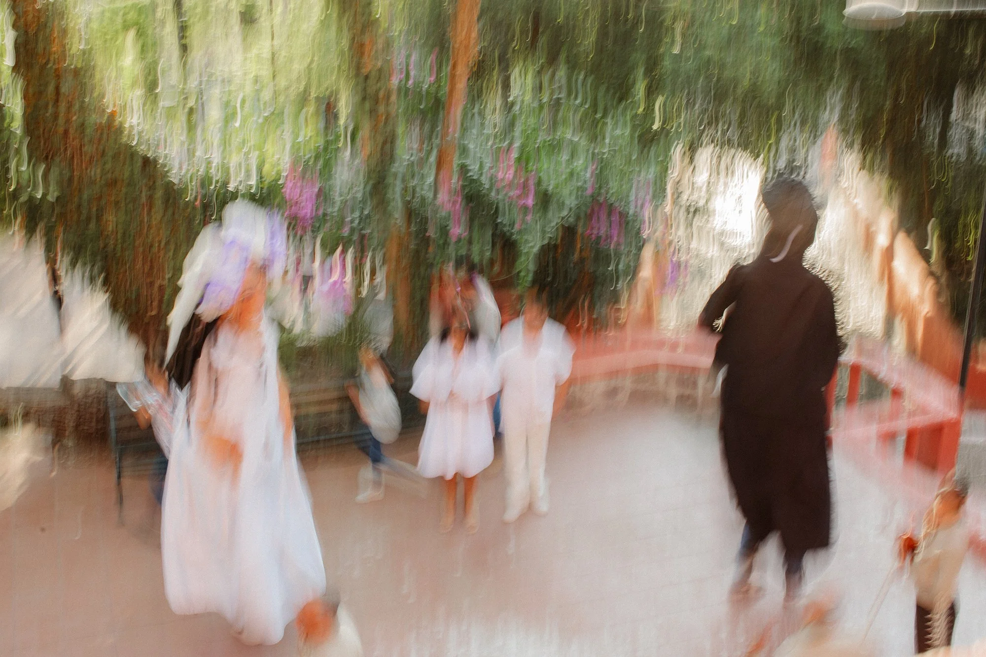 Bride tossing bouquet with guests reaching to catch it.