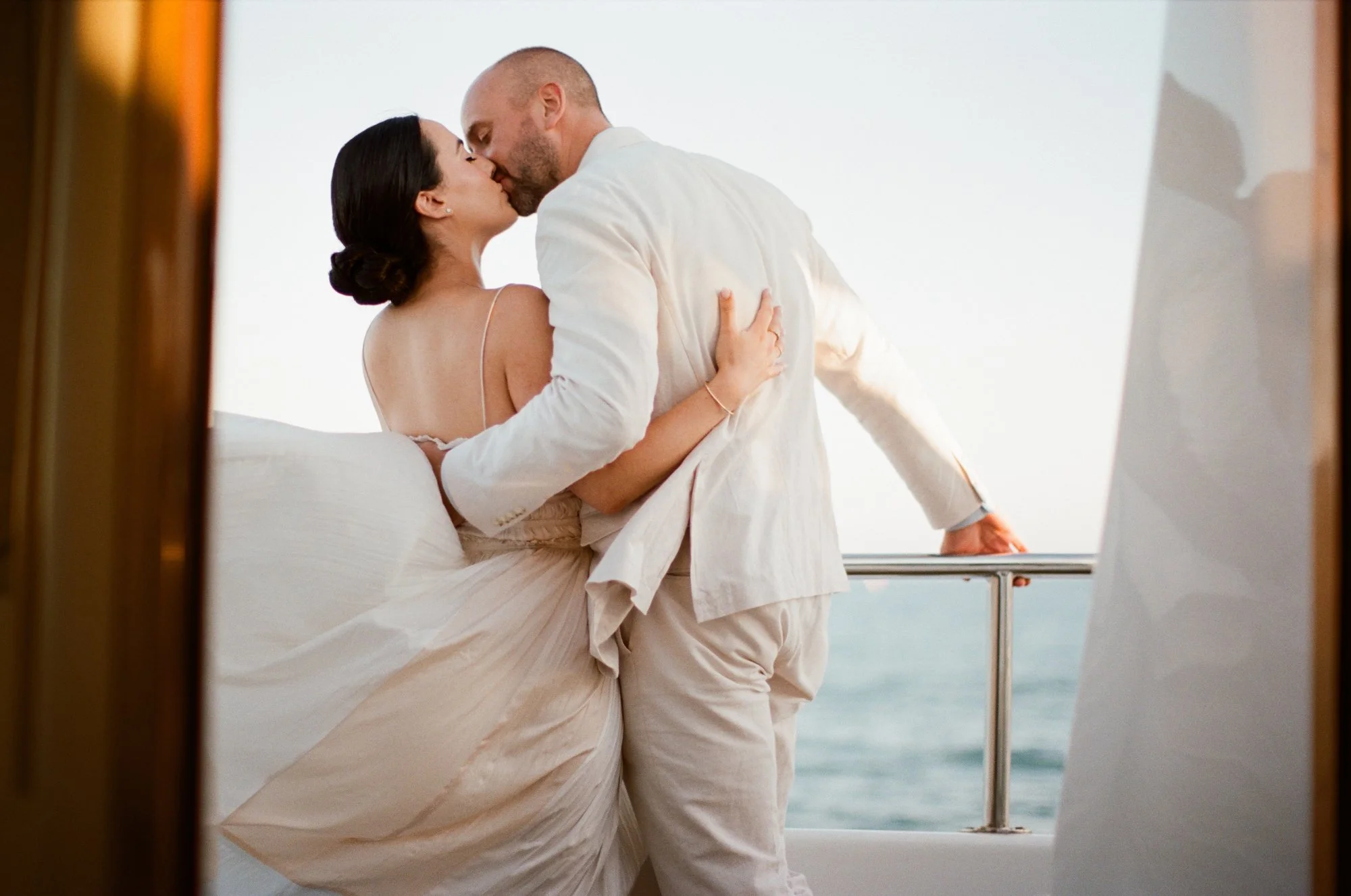 Bride and groom laughing and embracing on the yacht.