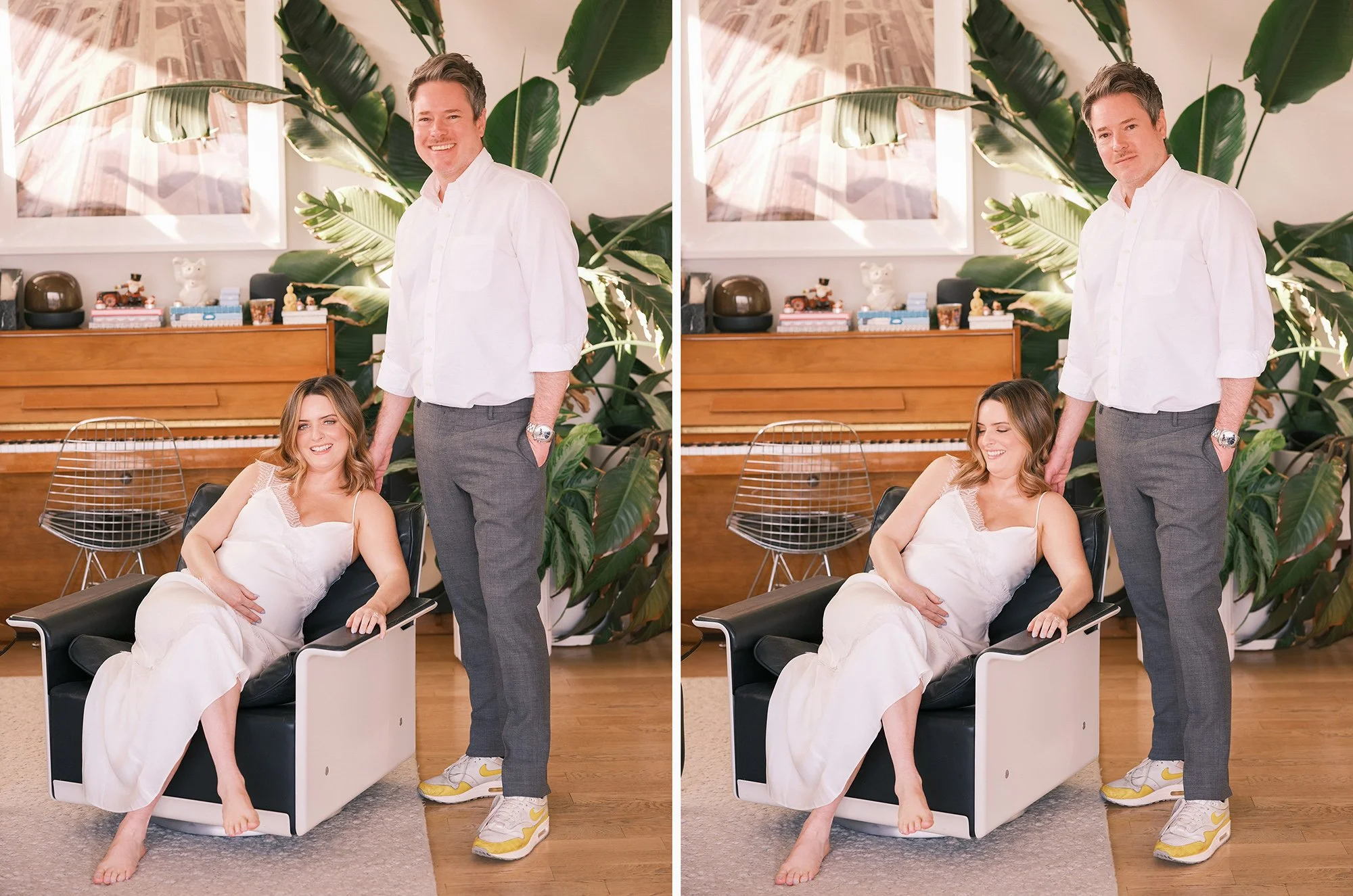 Couple posing together indoors, woman seated and man standing beside her in a living room with plants.