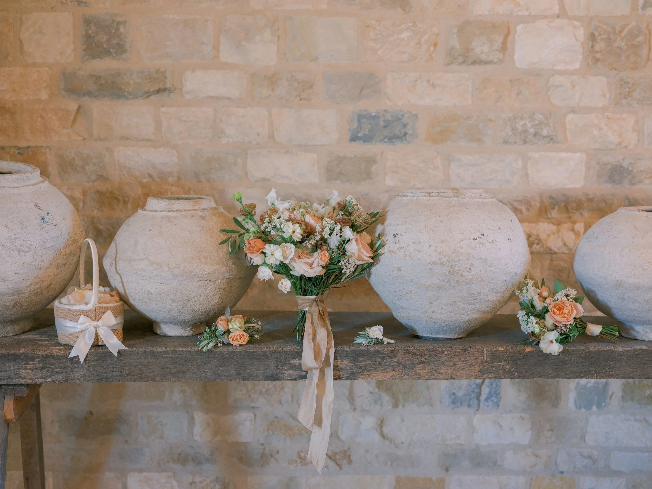 Ceramic vases with floral arrangements on a stone mantel at Sunstone Villa wedding, photographed by Michael & Anna Costa