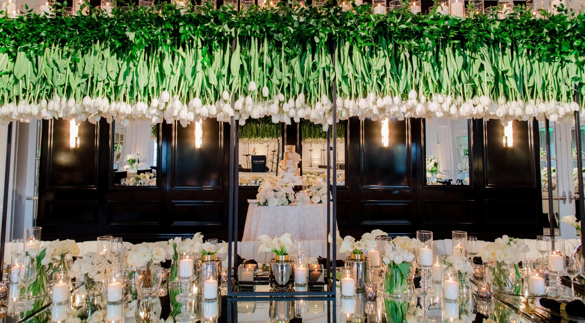 Indoor wedding reception with hanging greenery and elegant table settings at Rosewood Miramar Beach, photographed by Michael & Anna Costa
