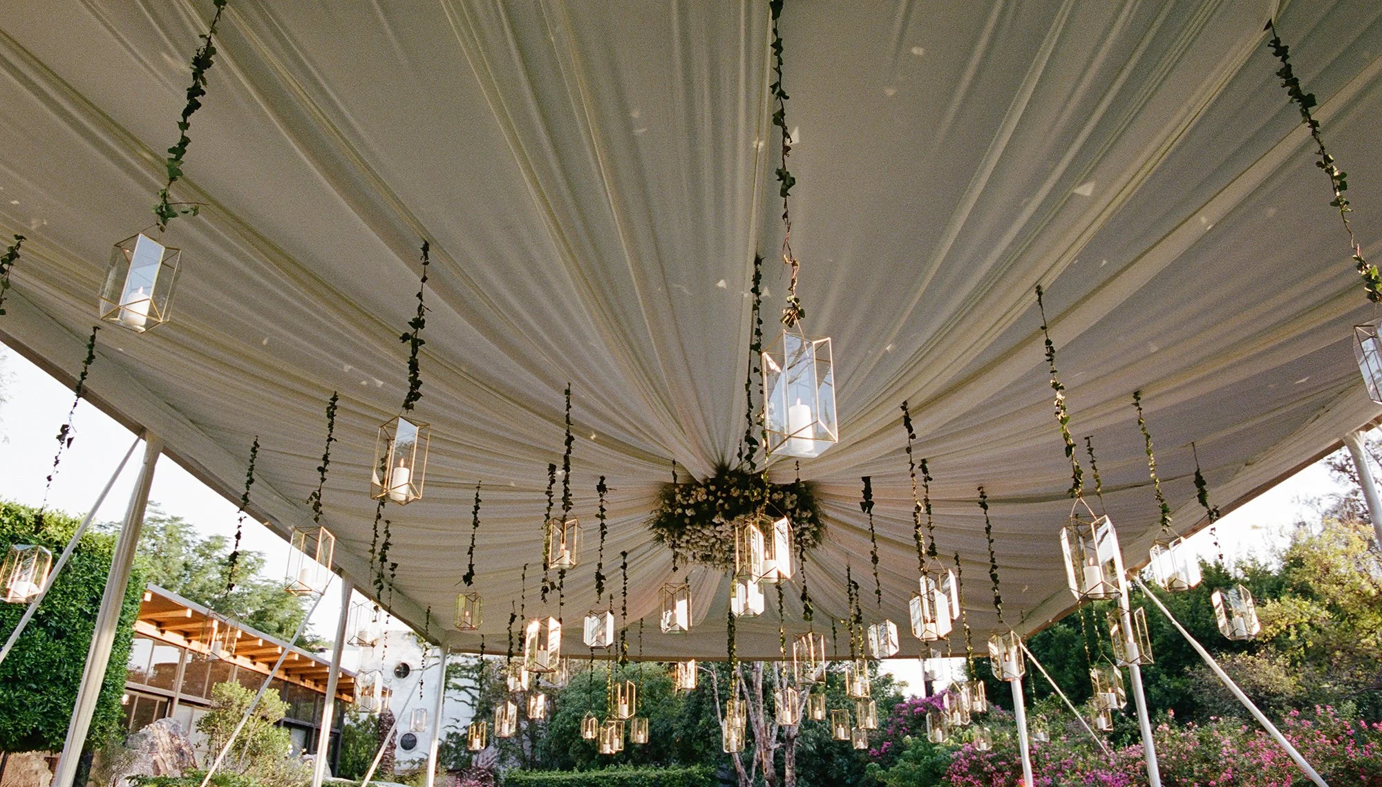 Outdoor wedding reception with long banquet tables, white linens, floral centerpieces, and lush greenery at Belmond Resort Casa de Sierra Nevada.
