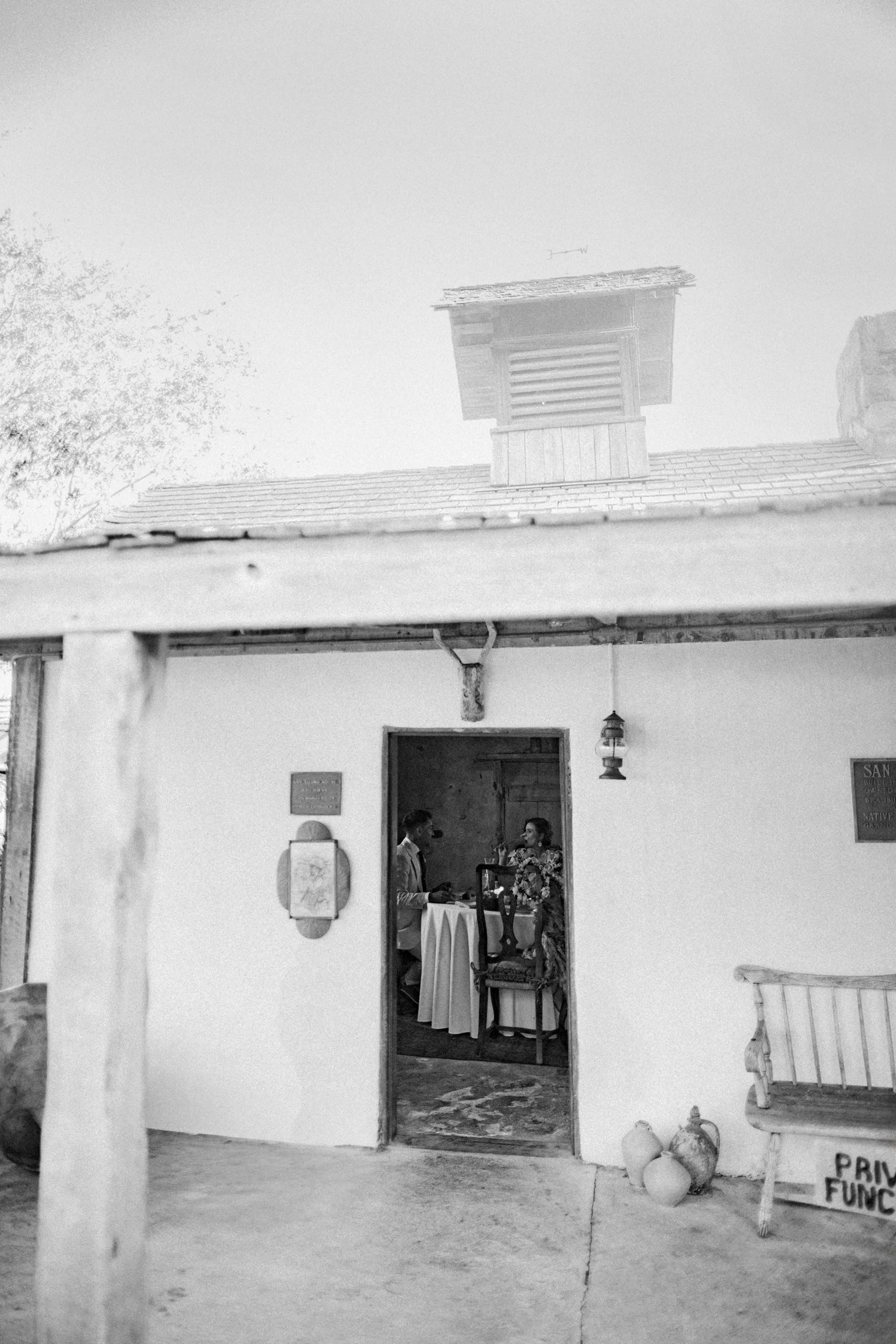 Black and white photo of a historic building with people standing in the doorway.