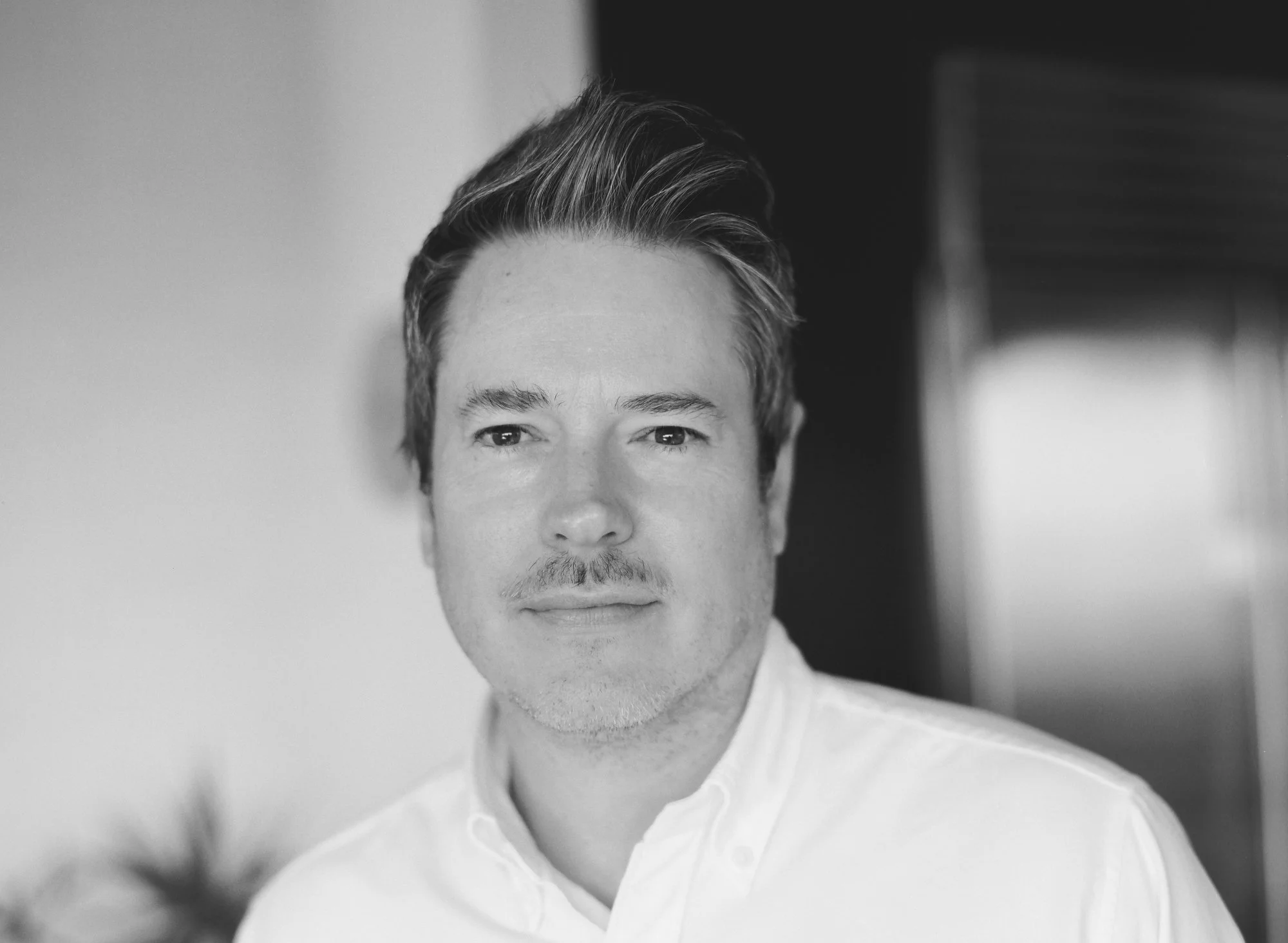 Black and white portrait of a man in a white shirt.