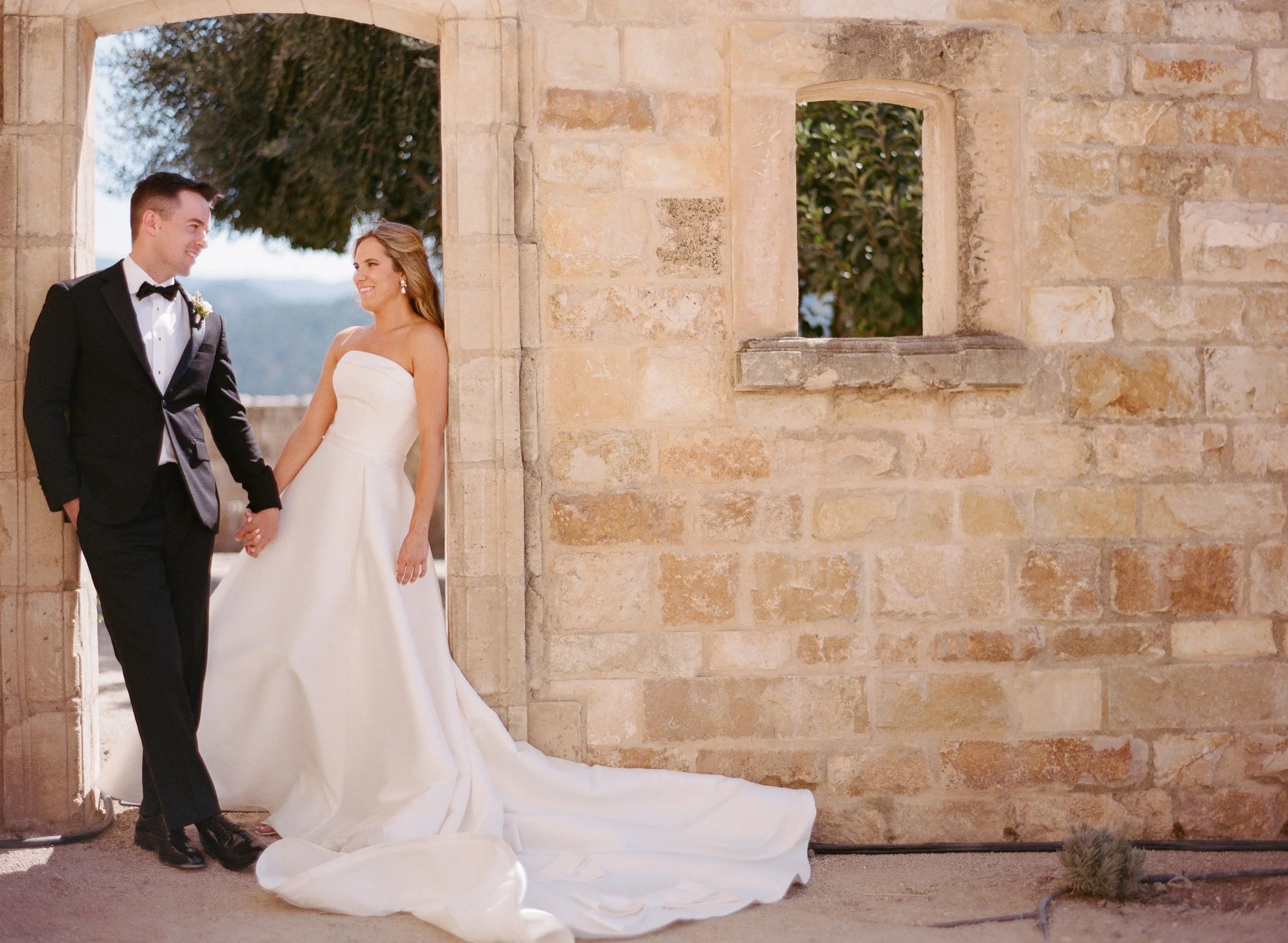 Bride and groom in a stone corridor
