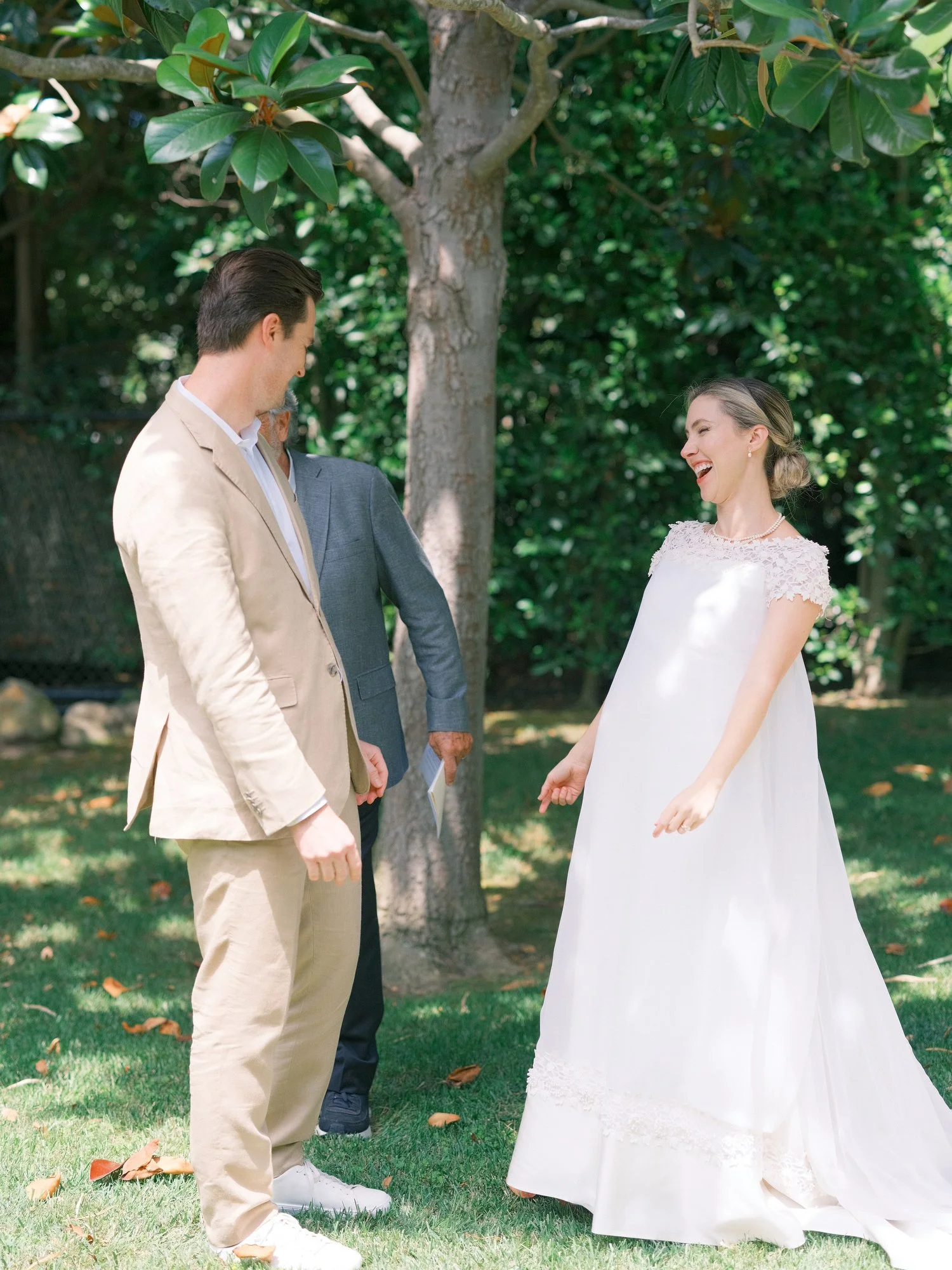 Bride and groom walking together on the lawn, bride holding her bouquet.