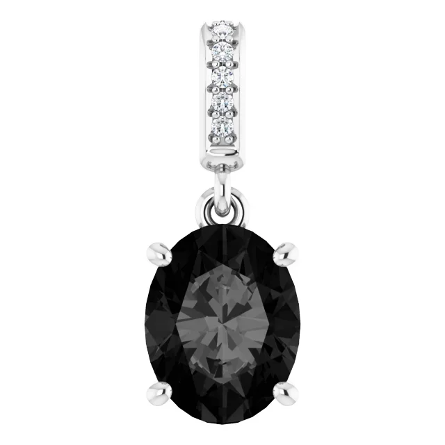 A silver pendant with a black oval gemstone, accented by small clear stones on the bail.