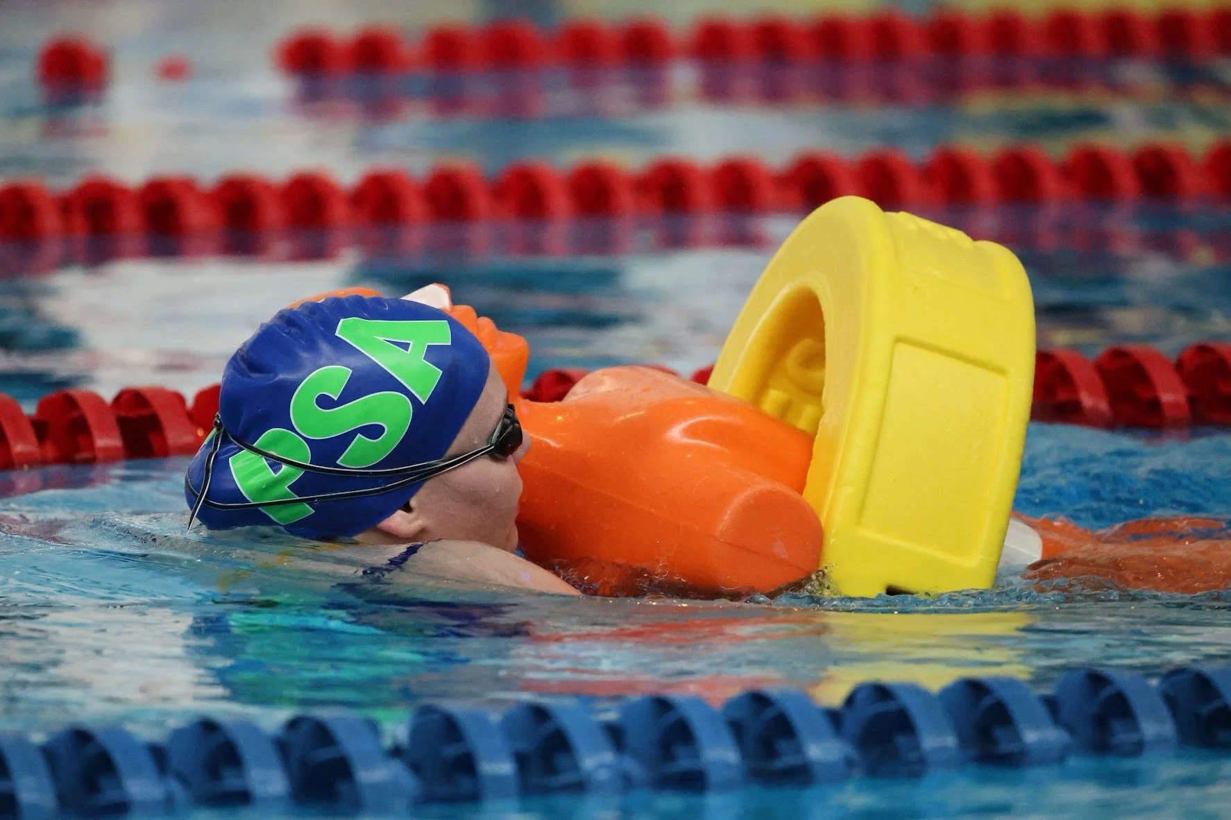 Open National pool lifesaving athlete carrying a rescue manikin