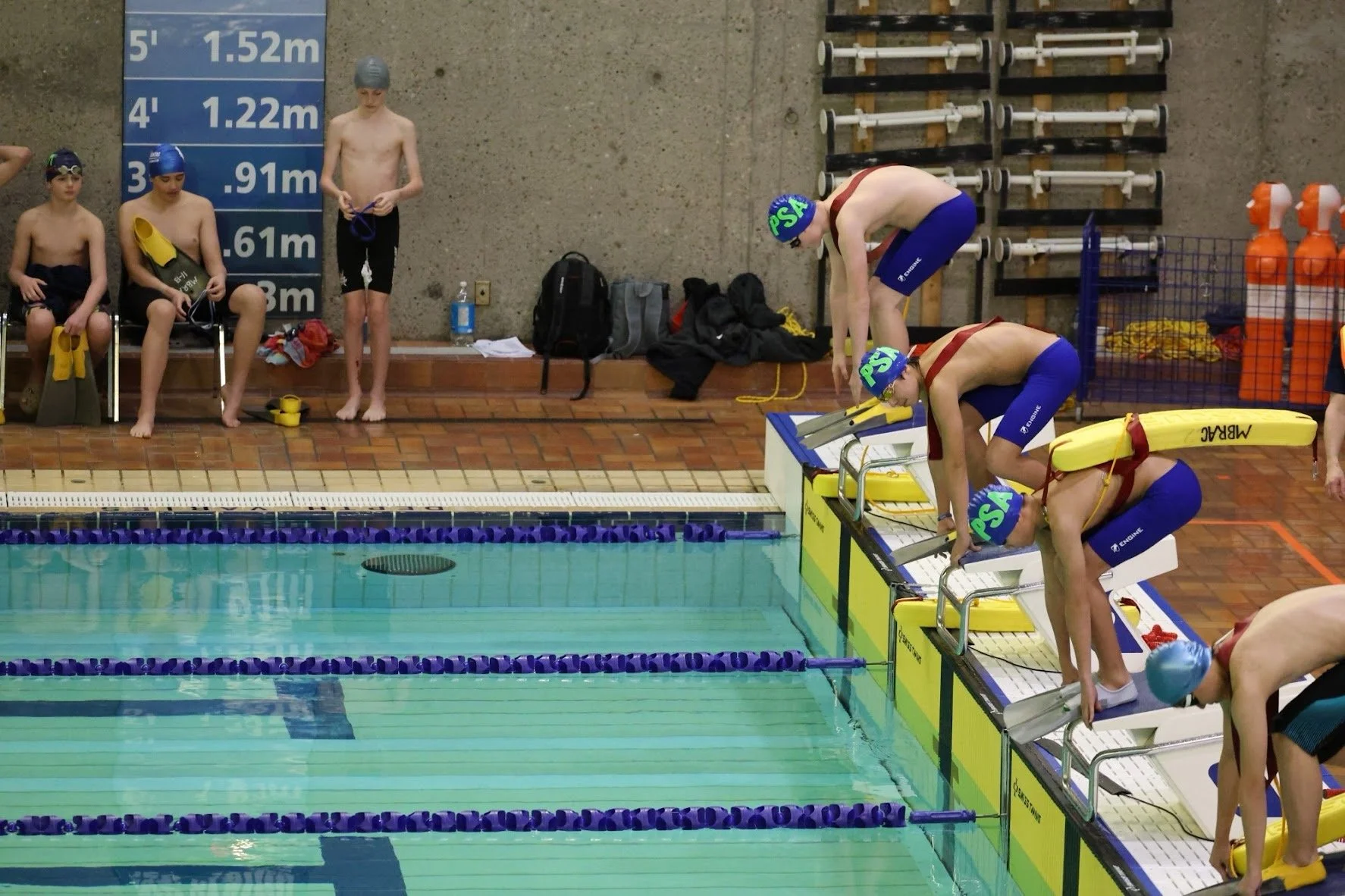 Youth National pool lifesaving athletes preparing on starting blocks