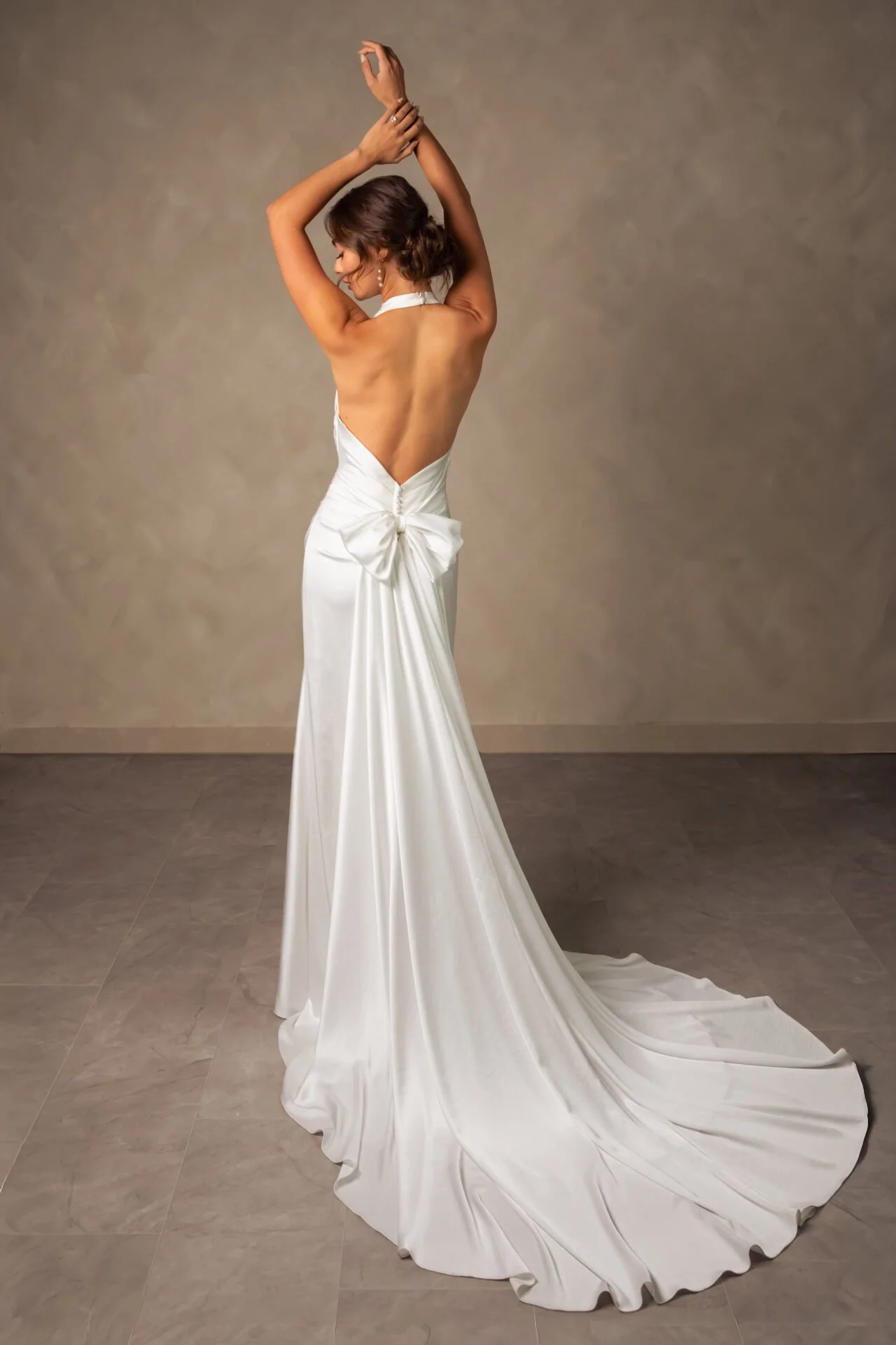 Fitted charmeuse Essense of Australia wedding dress with halter neck and low back. Detachable bow train.