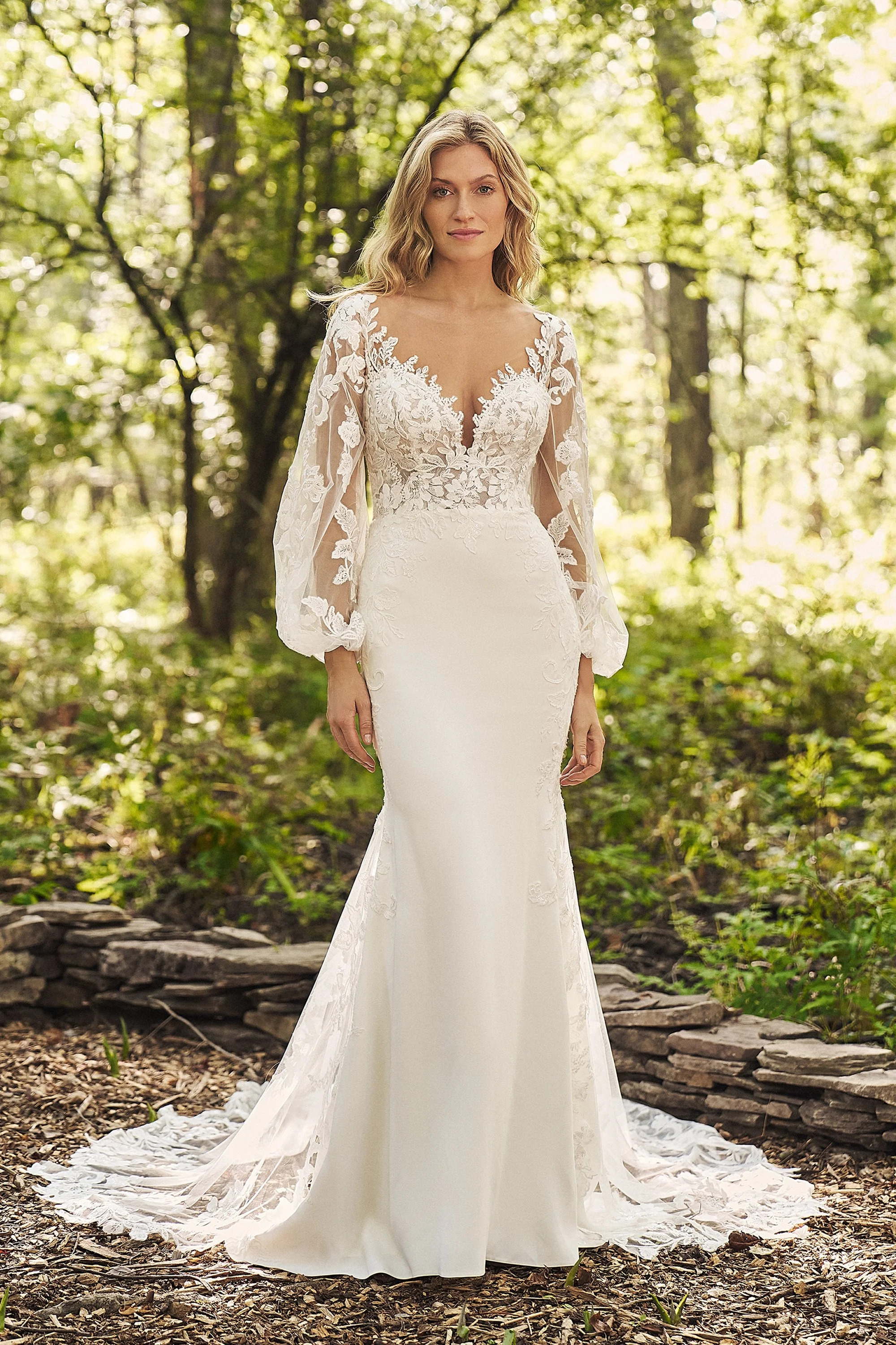 Crepe and tulle Lillian West wedding dress with detachable whimsical sleeves. Floral lace appliques on the bodice, sleeves and train.