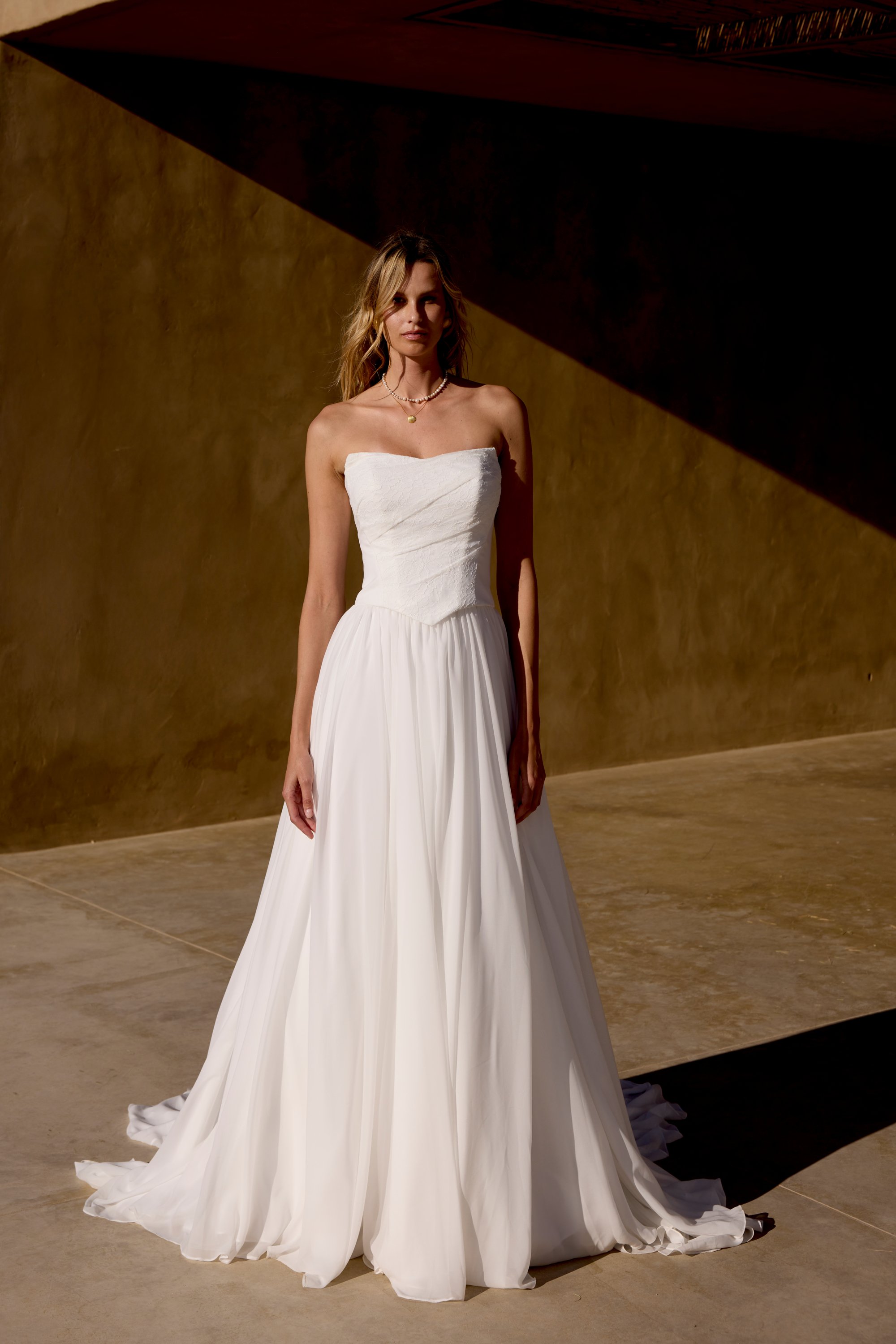 Lillian West wedding dress with chiffon skirt and basque waist corset bodice with cat eye neckline.