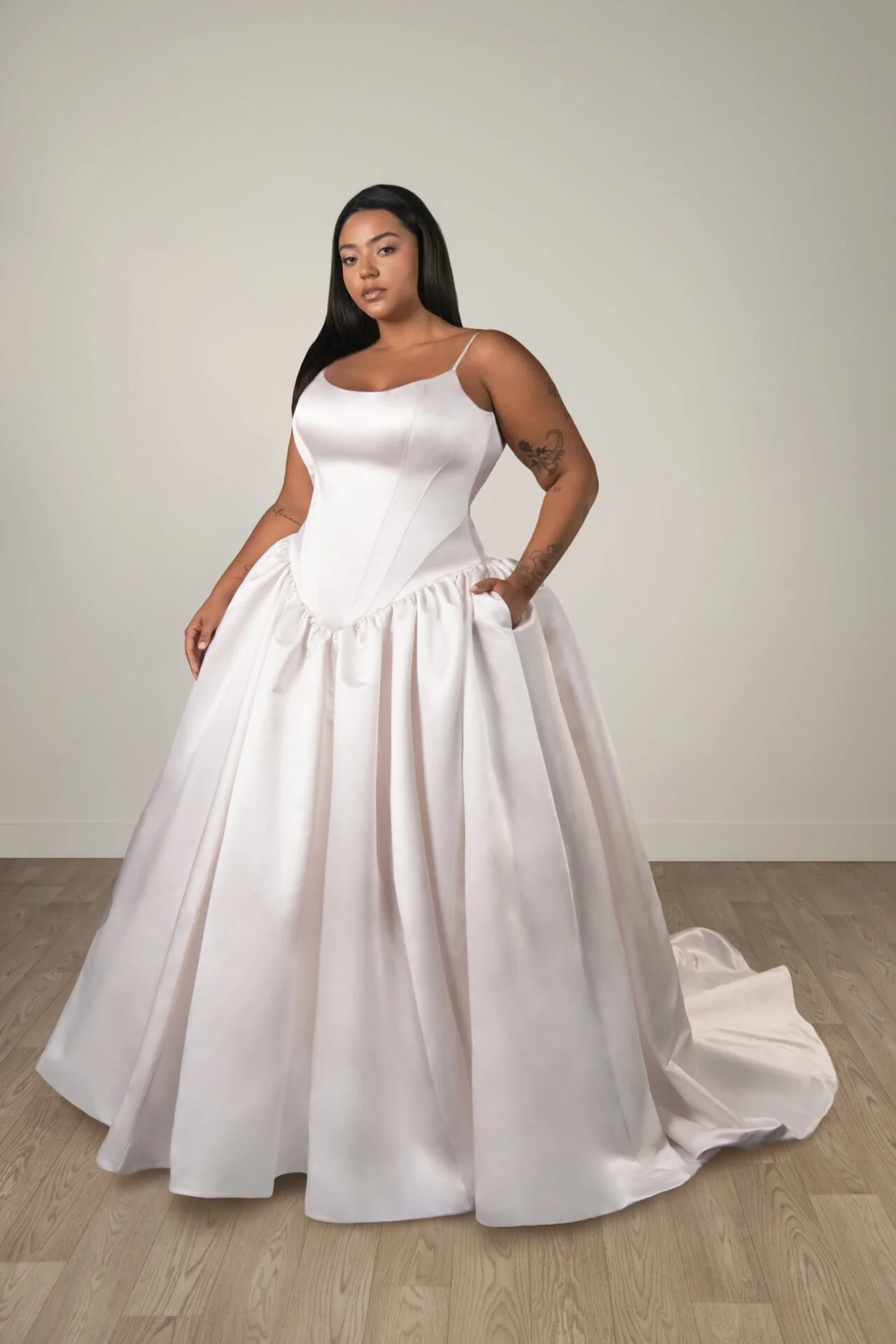 Plus size dropped basque waist Stella York ball gown in blush colored satin. Swoop neckline leading into spaghetti straps.