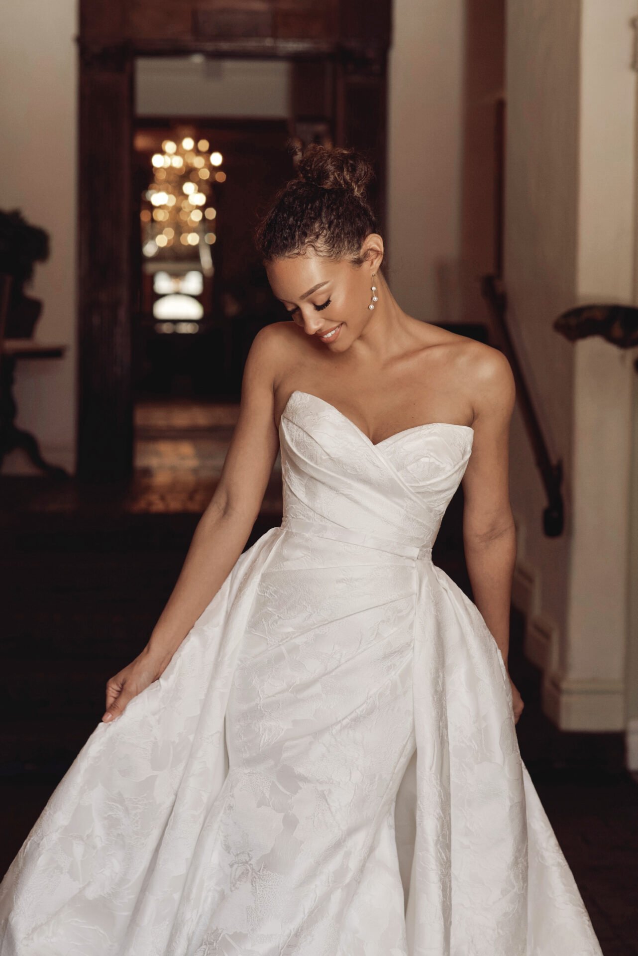 Essense of Australia fit-and-flare satin jacquard wedding dress with detachable overskirt train and crisscross sweetheart neckline.