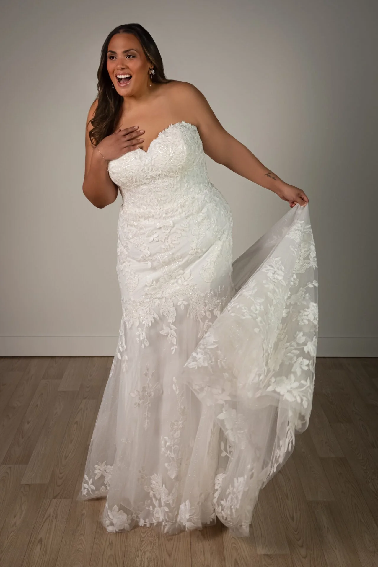 Plus size fit-and-flare lace and tulle beaded Stella York wedding gown with floral appliques throughout leading to a floral lace and tulle train with sweetheart neckline and glitter underlay.