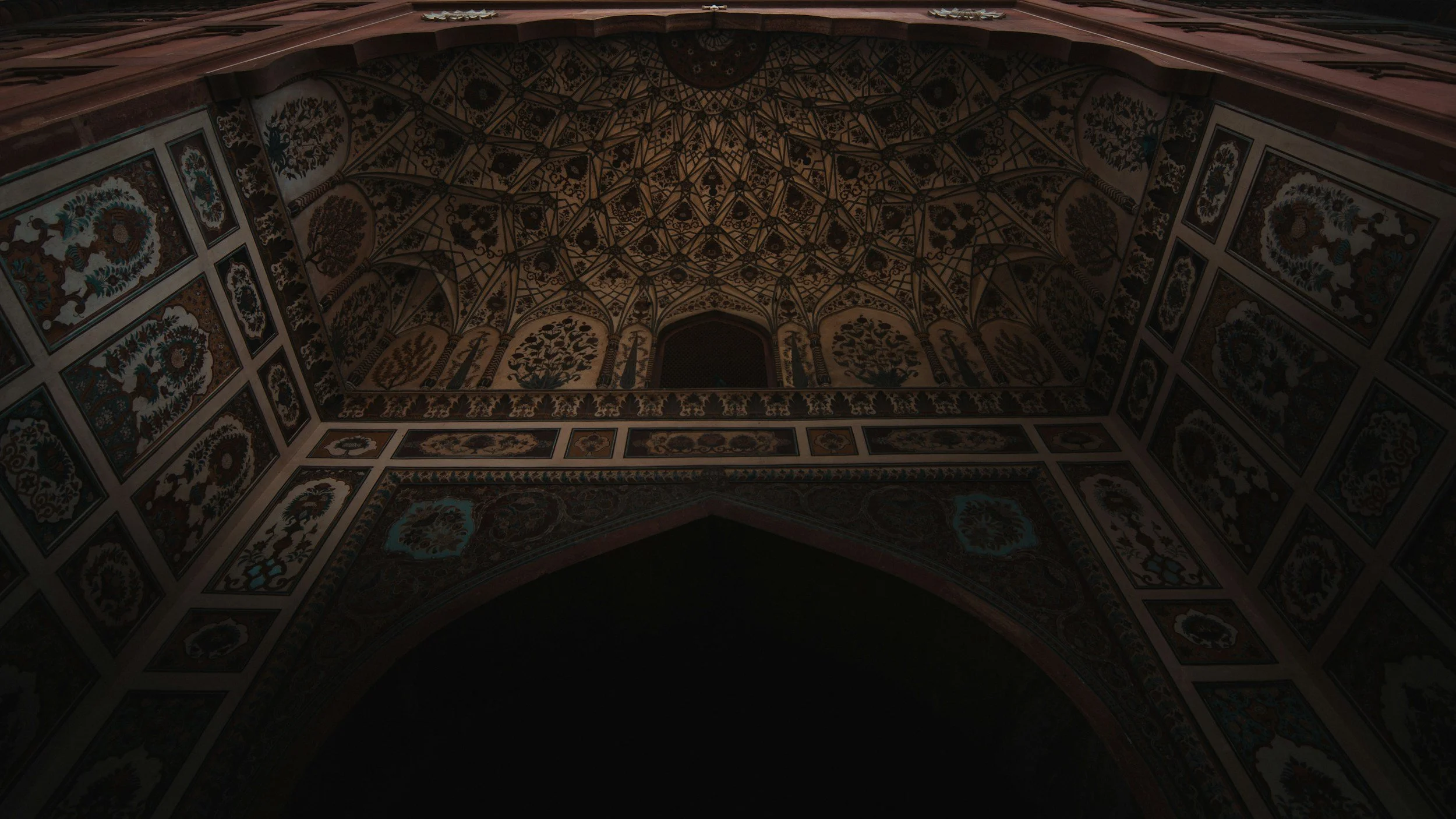 Patterned architectural wall with repeating geometric openings and deep shadows