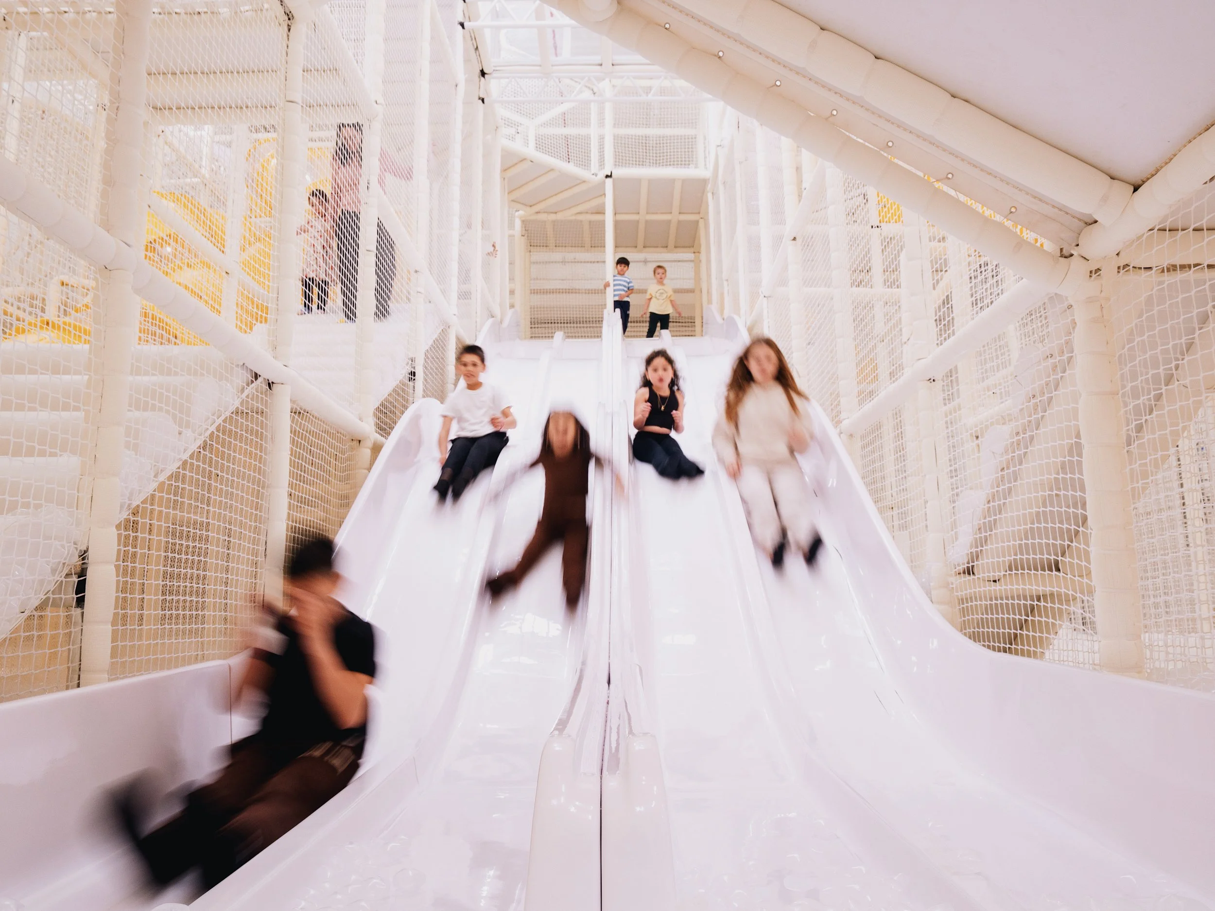 Children sliding down a slide structure at Space Club DUMBO, Brooklyn.