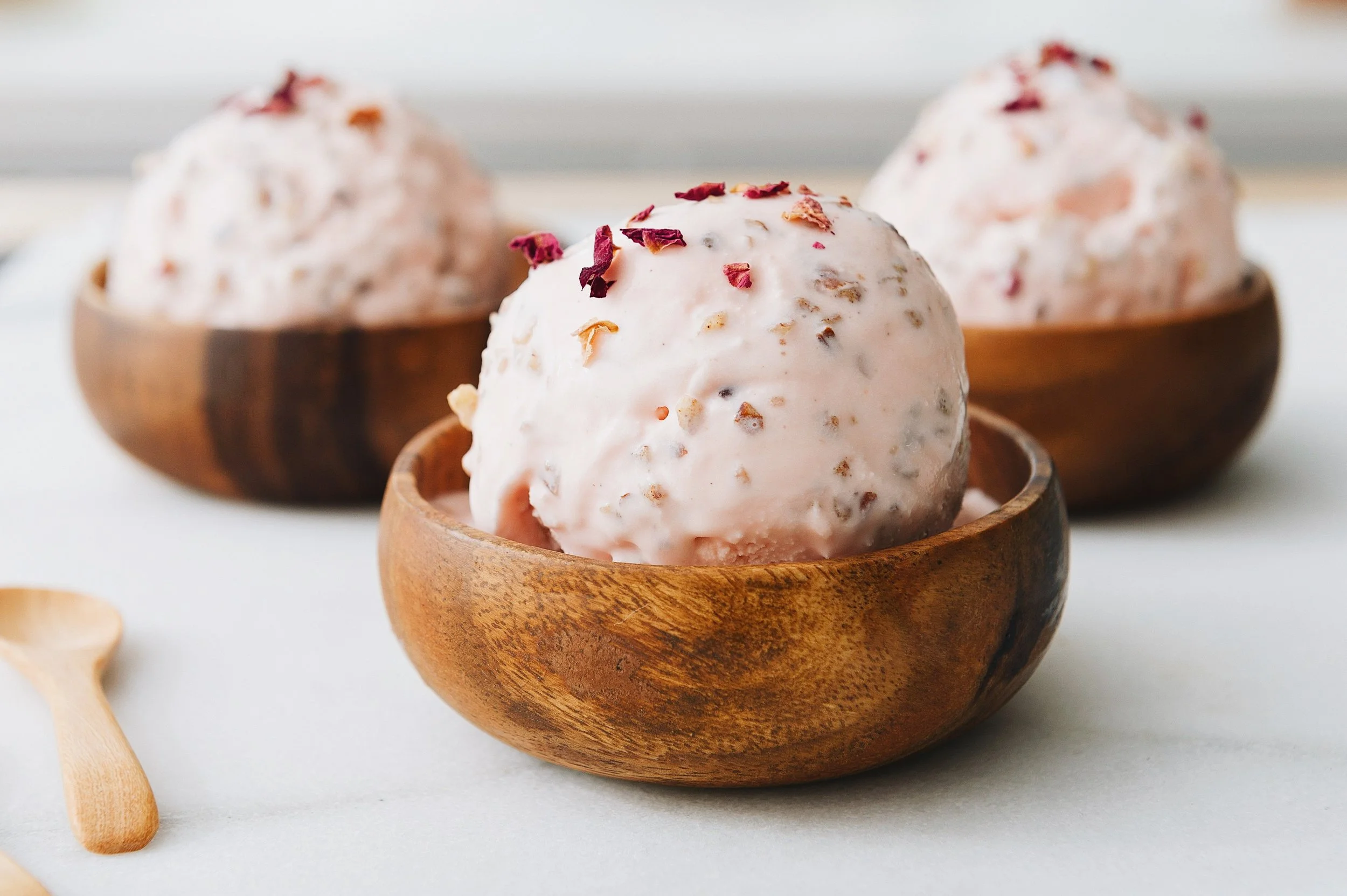 Rose ice cream with cinnamon roasted almonds, Malai Ice Cream, served in a wooden bowl