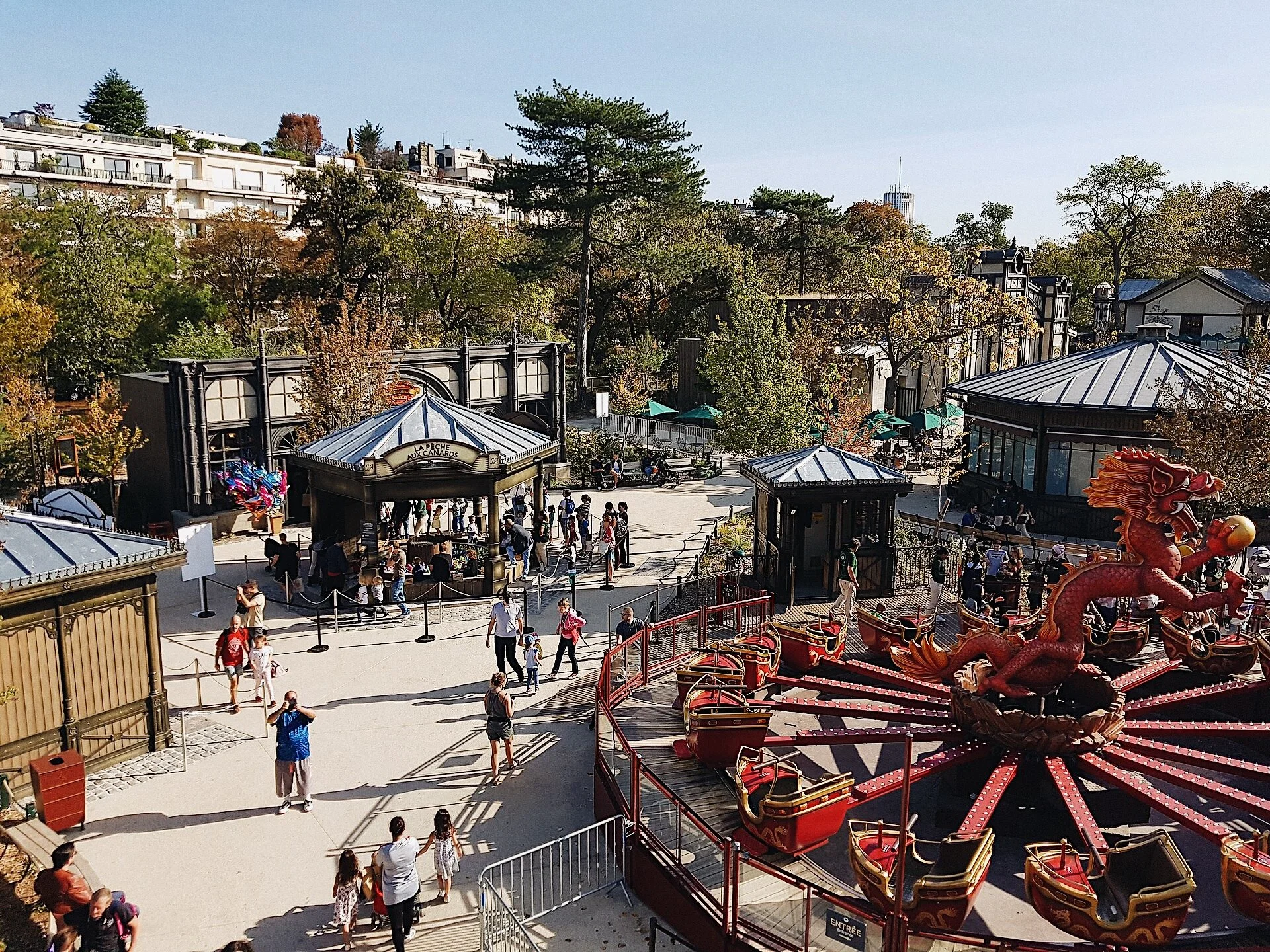 Aerial view of Jardin d'Acclimatation in the Bois de Boulogne, with vintage rides, pavilions, and families