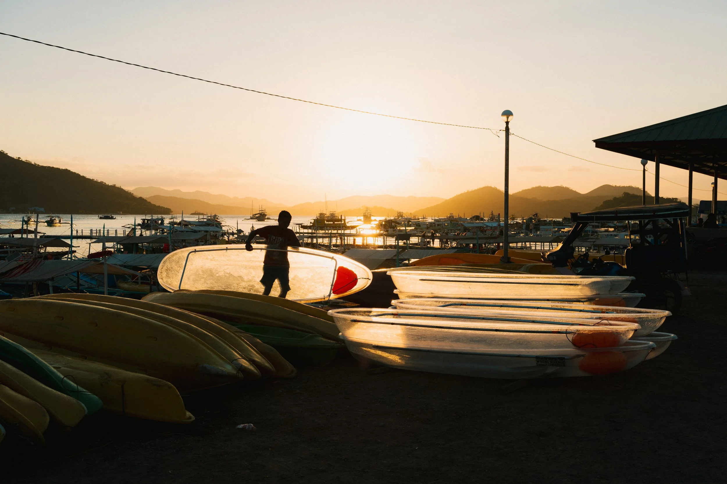 Man with clear kayaks during golden hour in Coron, the Philippines 