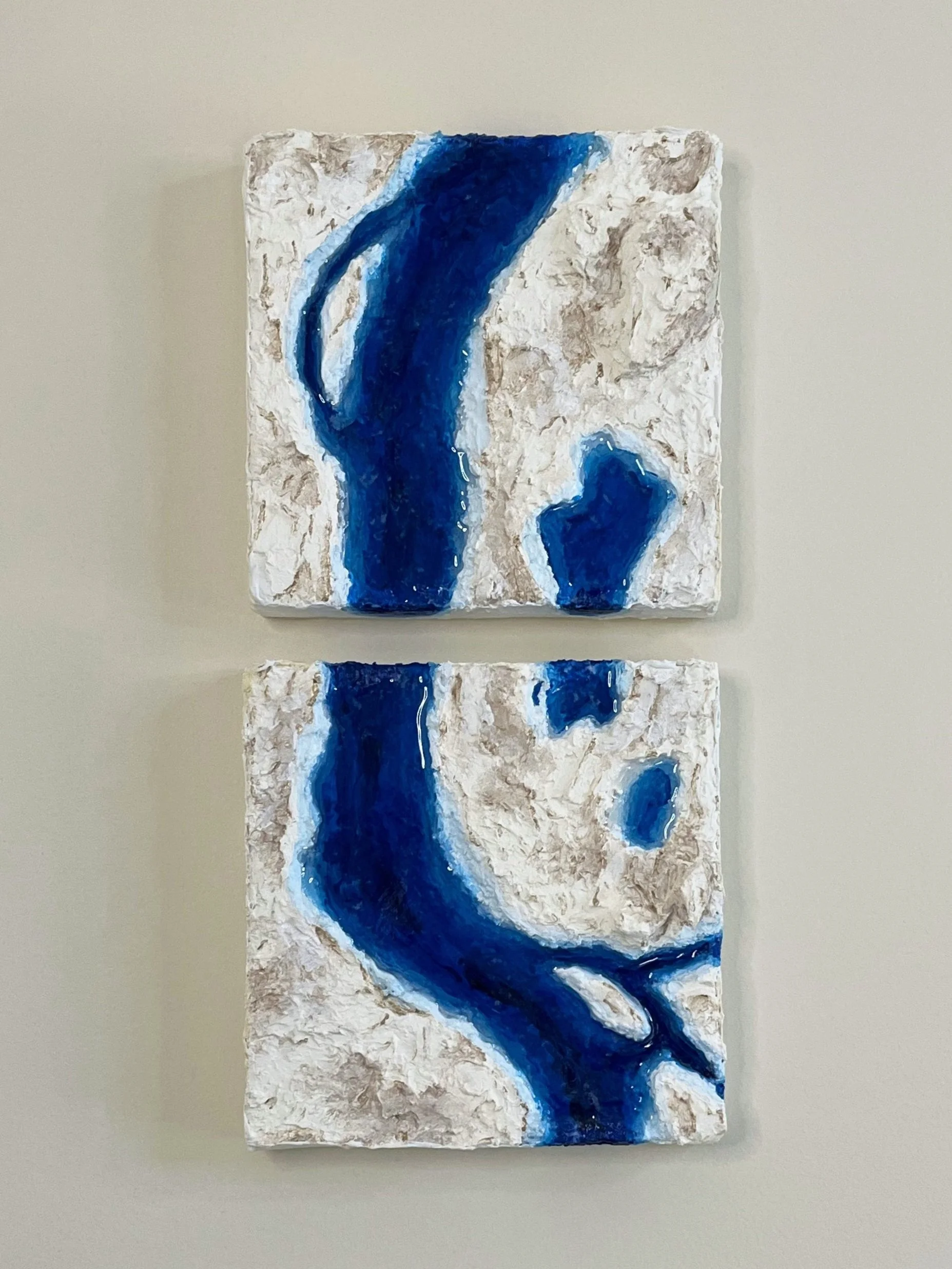 Abstract painting sculpture on textured white canvas with blue flowing streaks, hung vertically.