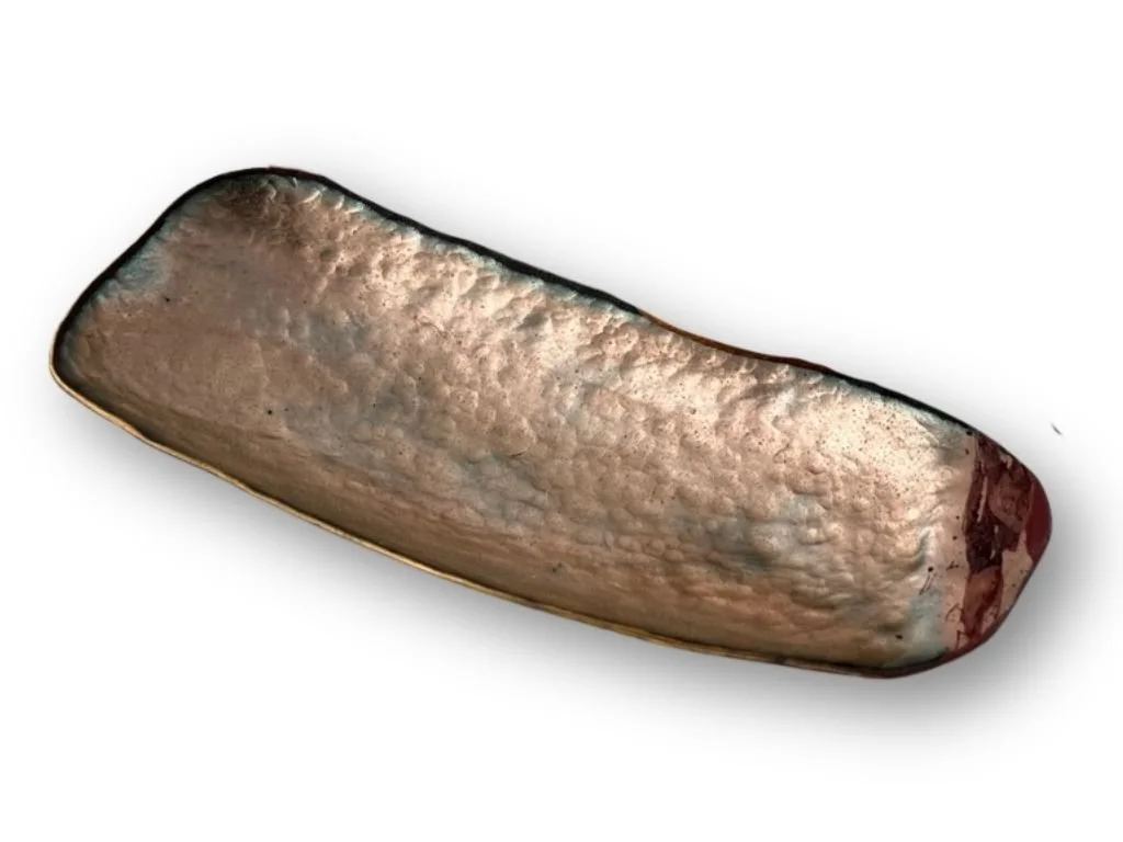 A small dish with an over-fired clear enamel glaze.