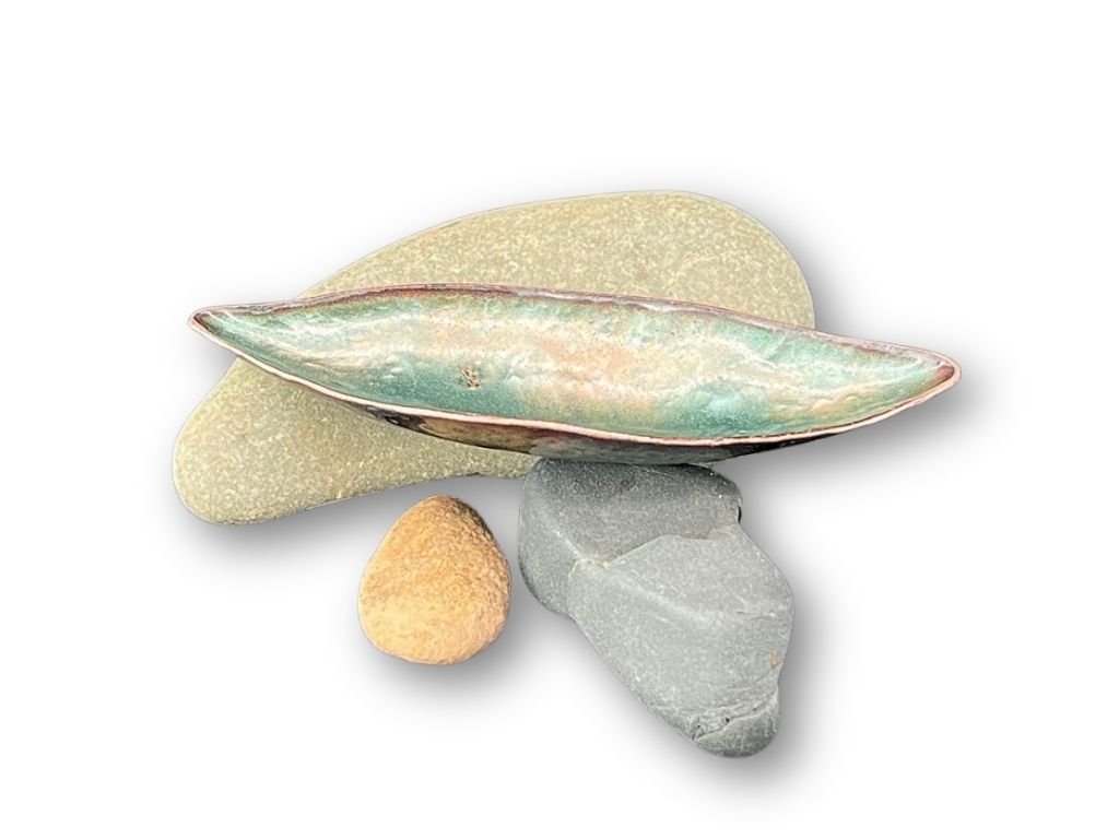 Arrangement of four rocks and an open shell on a white background.